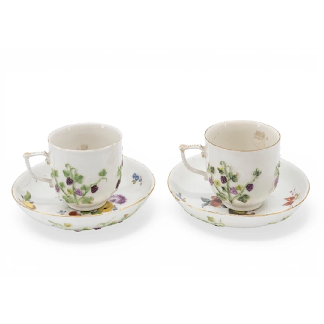 A PAIR OF MEISSEN CABINET CUPS AND SAUCERS decorated with ra...