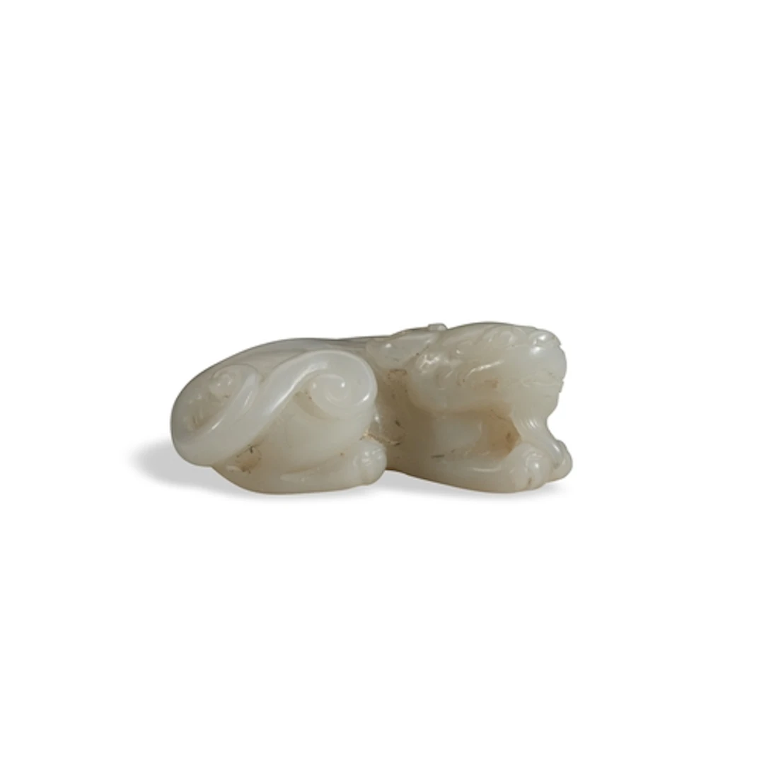 A WHITE JADE FIGURE OF A LION QING DYNASTY, 19TH CENTURY 白玉狮...