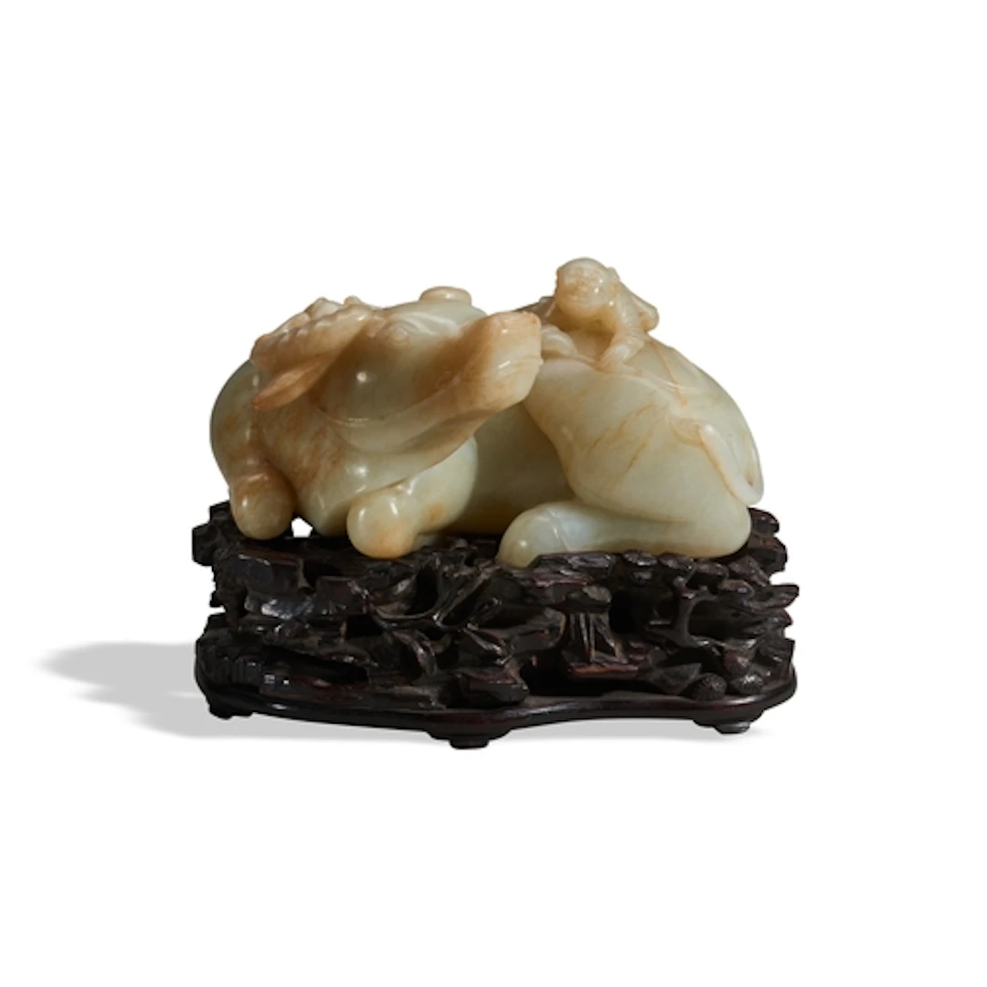 A PALE-CELADON AND RUSSET JADE BUFFALO QING DYNASTY (1644-19...
