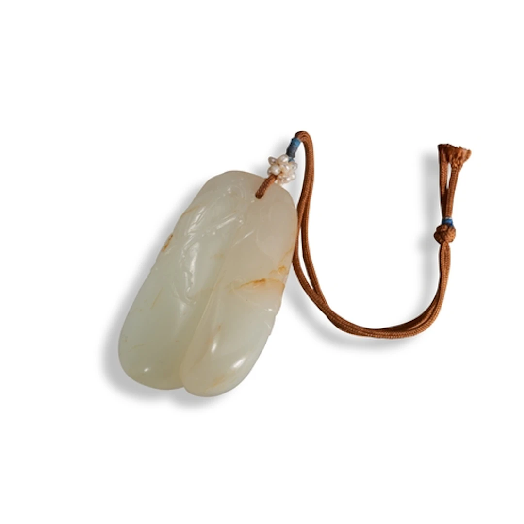 A WHITE AND RUSSET JADE 'MELON' PENDANT QING DYNASTY, 19TH C...