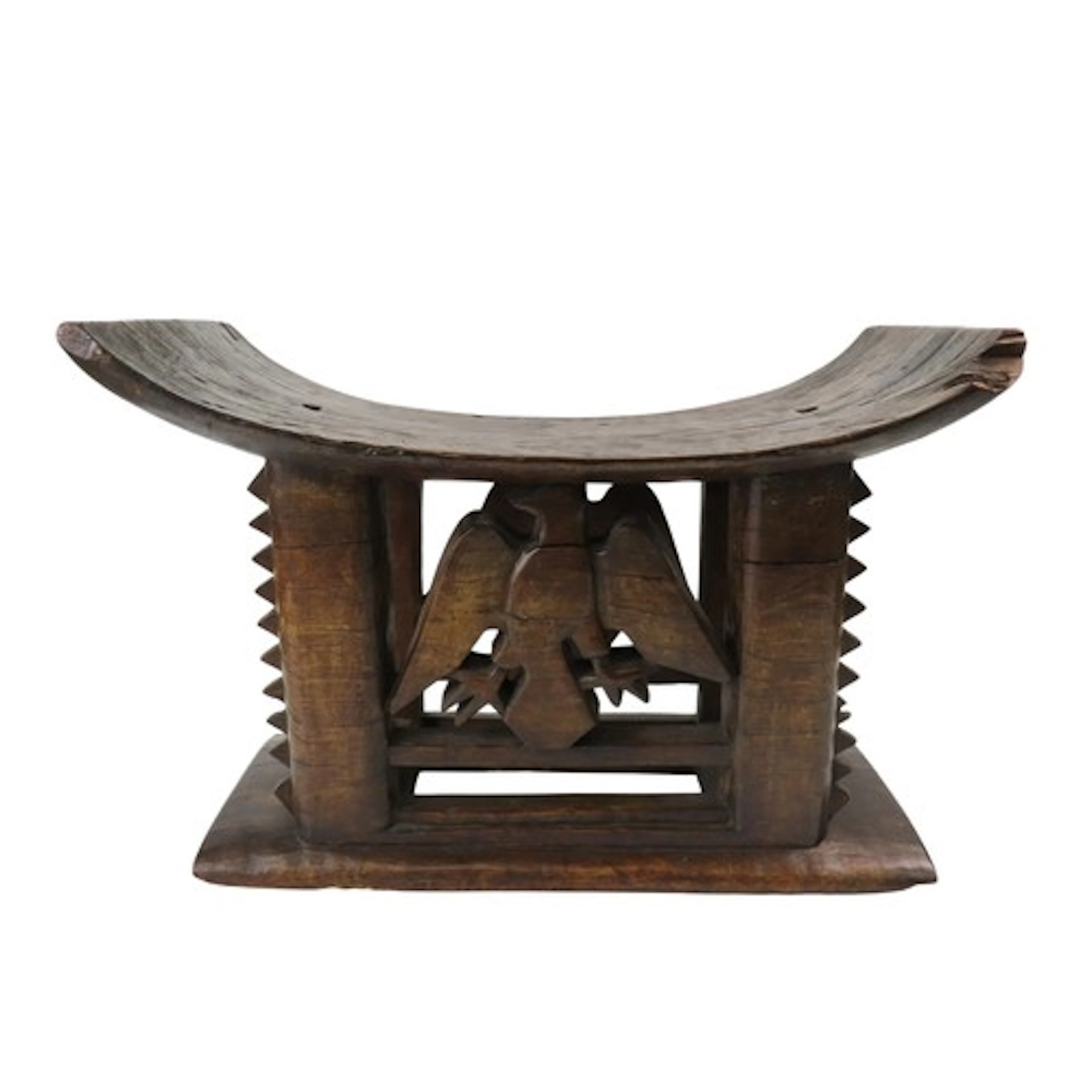 AN ASHANTI CARVED WOODEN STOOL, the curved top over serrated...