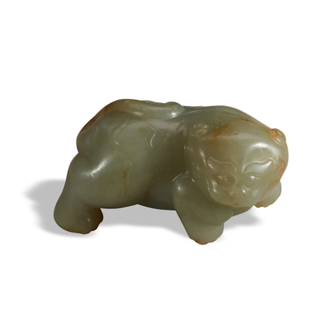 A CELADON AND RUSSET JADE ARCHAIC-STYLE LION QING DYNASTY, 1...