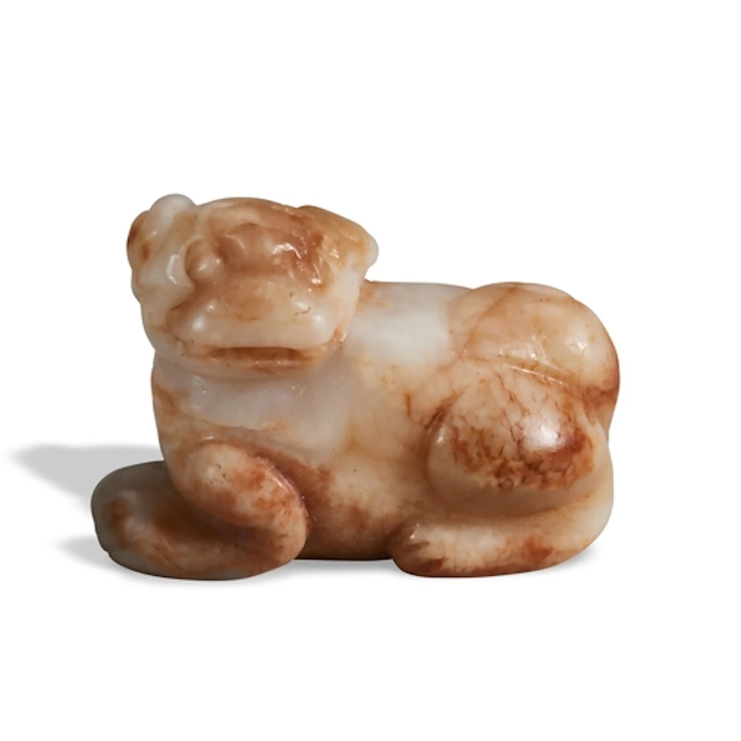 A CARAMEL-RUSSET JADE FIGURE AND A LION QING DYNASTY, 19TH C...