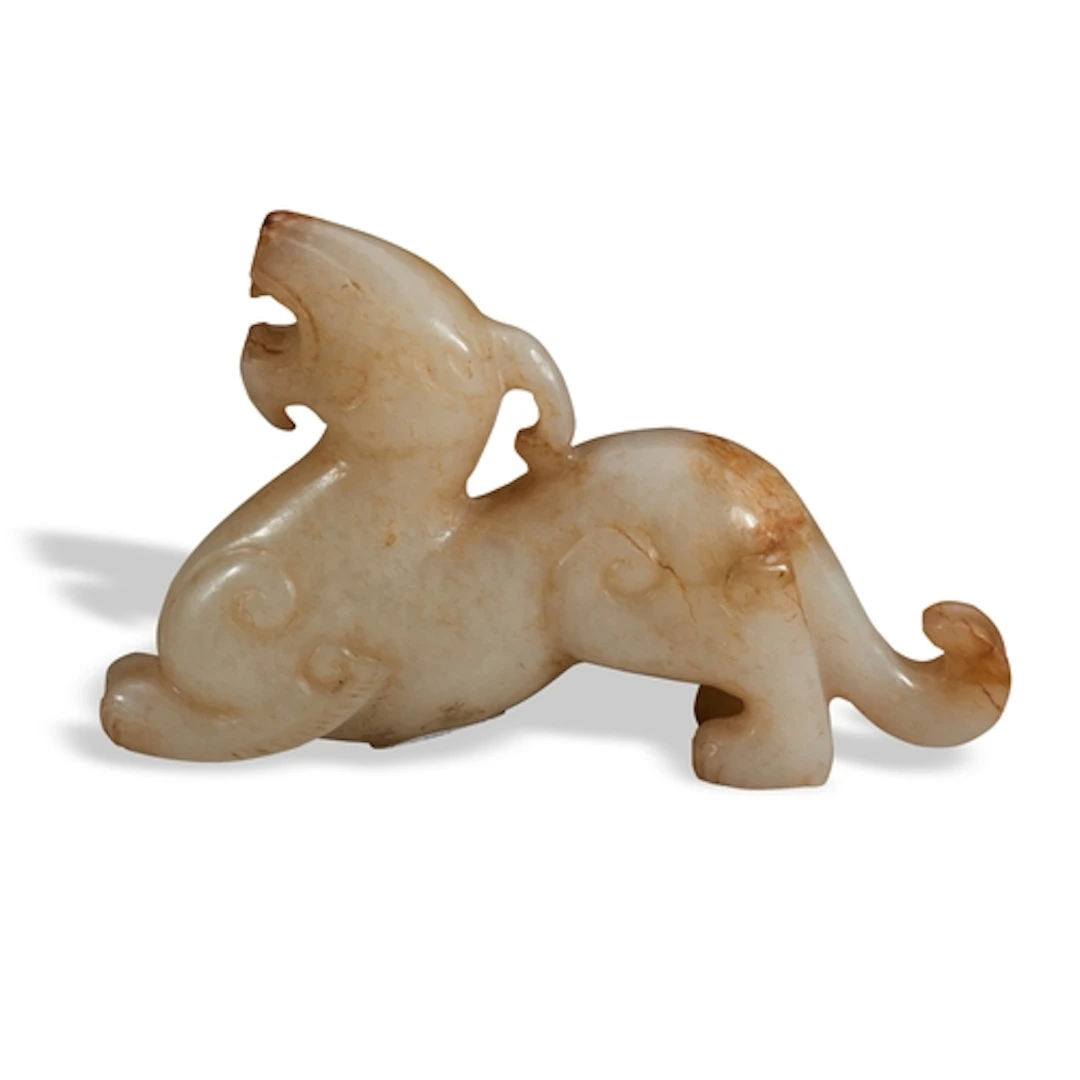 A MOTTLED WHITE JADE CHIMERA QING DYNASTY, 19TH CENTURY 黄褐玉...