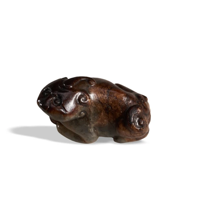 A MOTTLED-GREYISH JADE FIGURE OF A HORNED CHIMERA 17TH / 18T...