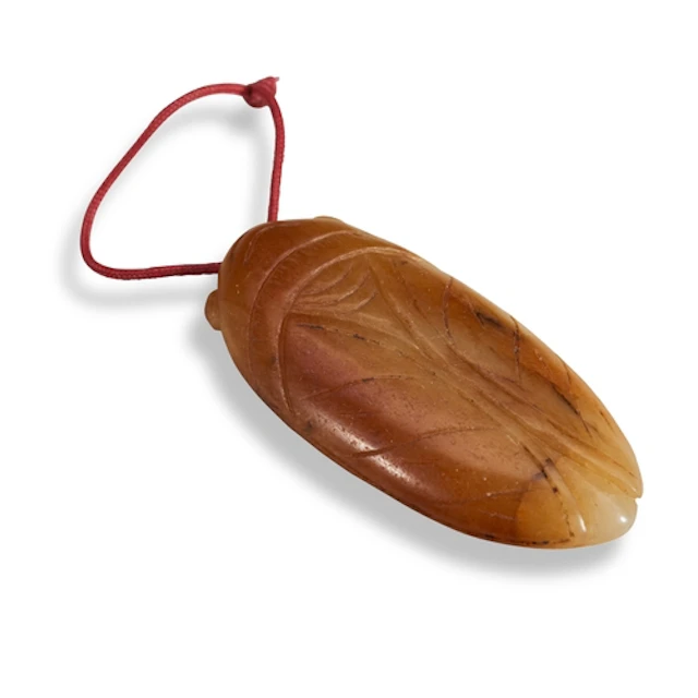 A HONEY AND RUSSET JADE 'CICADA' PENDANT 17TH CENTURY 褐玉蝉 十七...