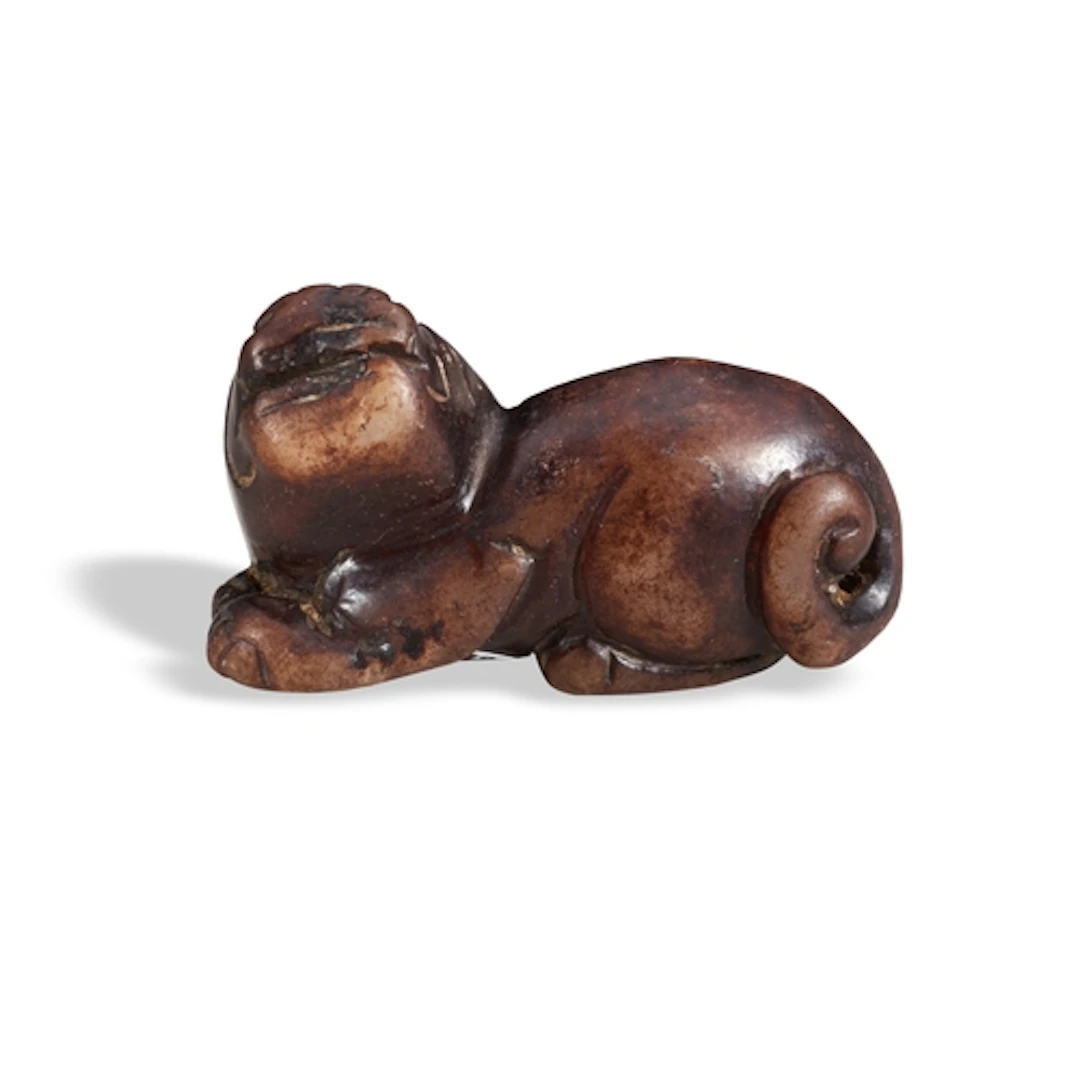 A BROWN JADE FIGURE OF A MYTHICAL BEAST QING DYNASTY, 19TH C...