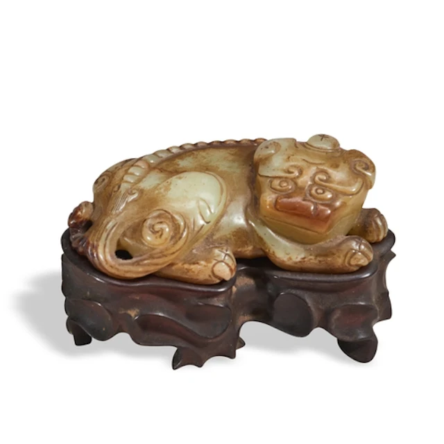 A YELLOW AND RURSSET JADE CARVING OF A MYTHICAL BEAST MING D...