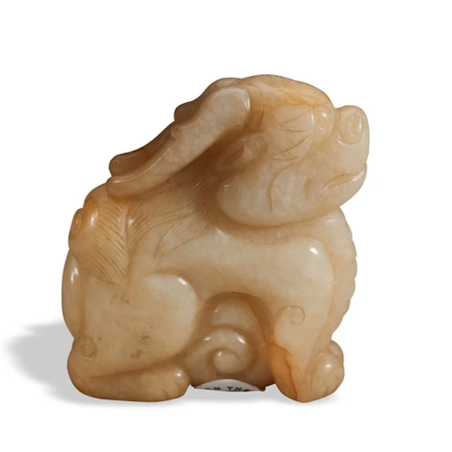 A MOTTLED CARAMEL JADE FIGURE OF BIXIE QING DYNASTY, 19TH CE...