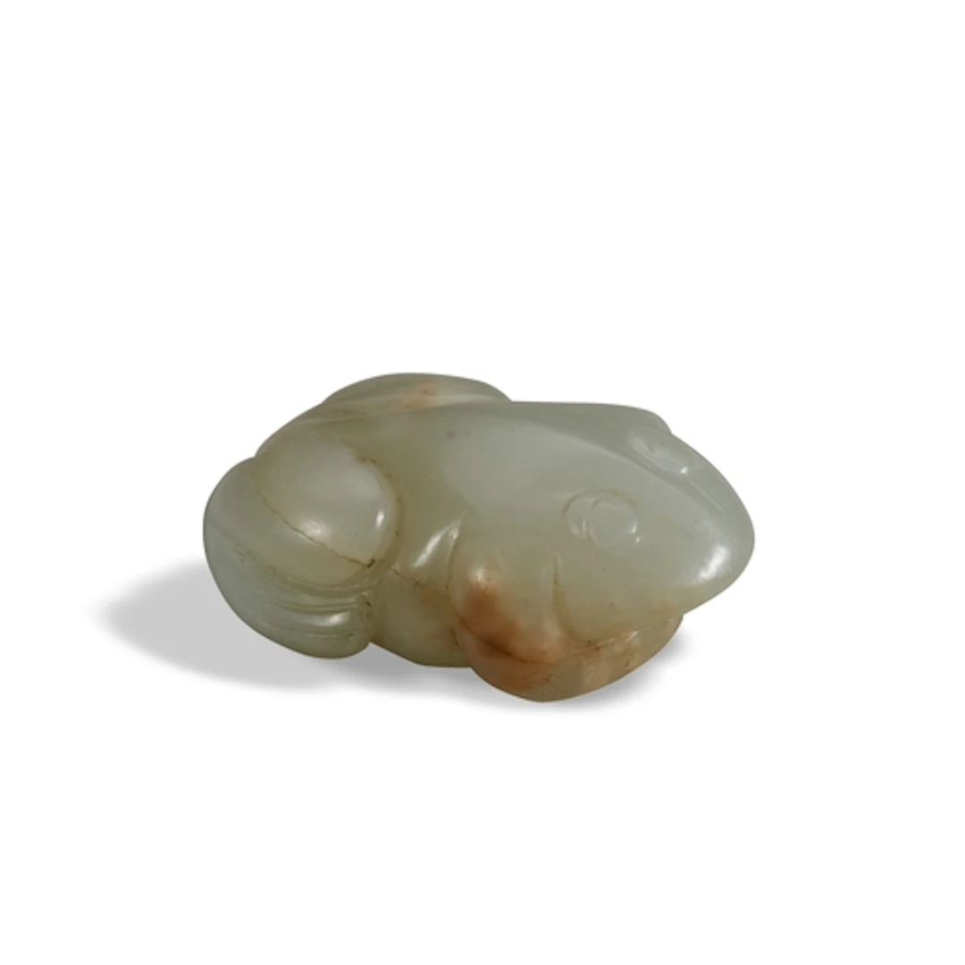 A MINIATURE CELADON AND RUSSET JADE FIGURE OF A TOAD PENDANT...