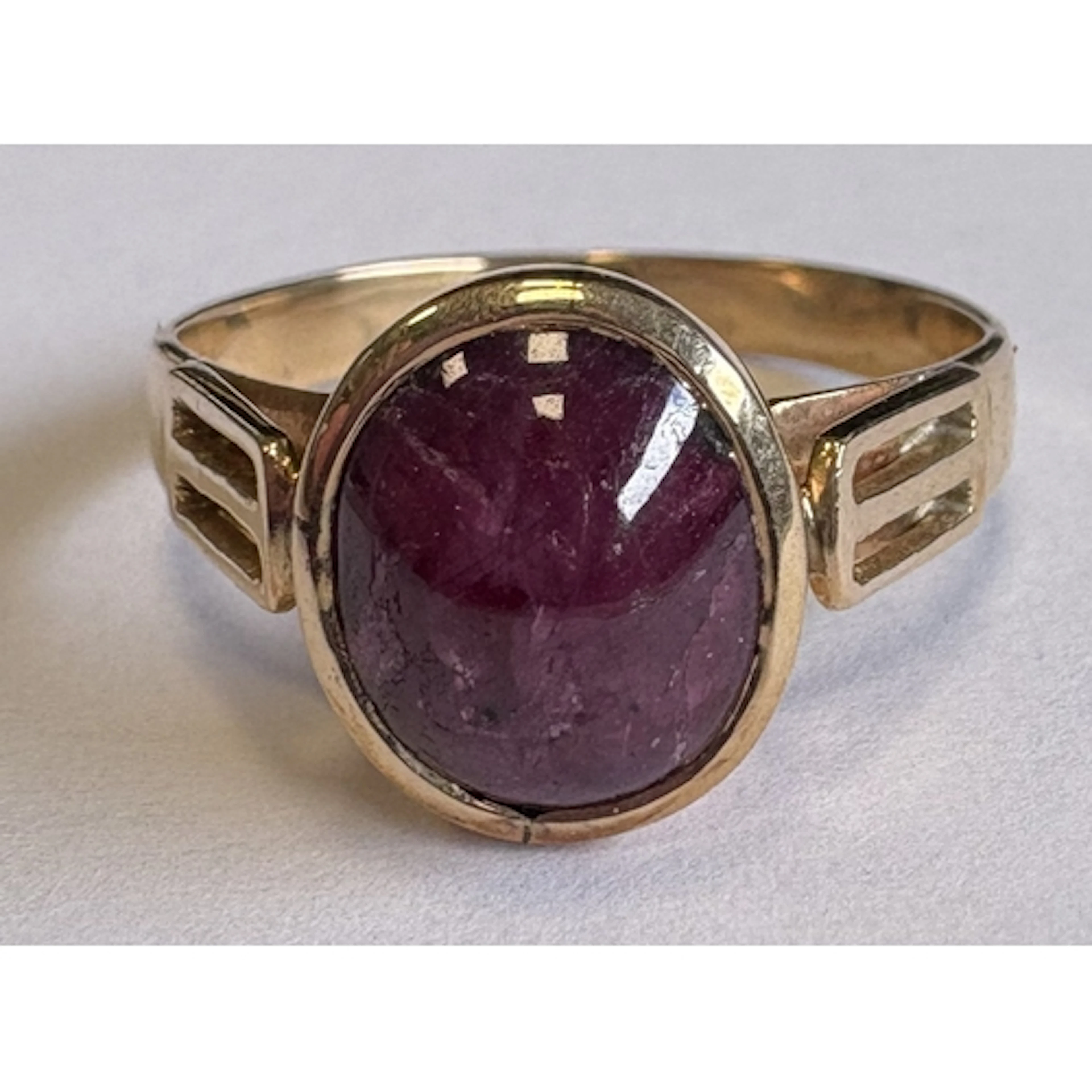 A single-stone cabochon ruby ring in gold setting. Approx. r...