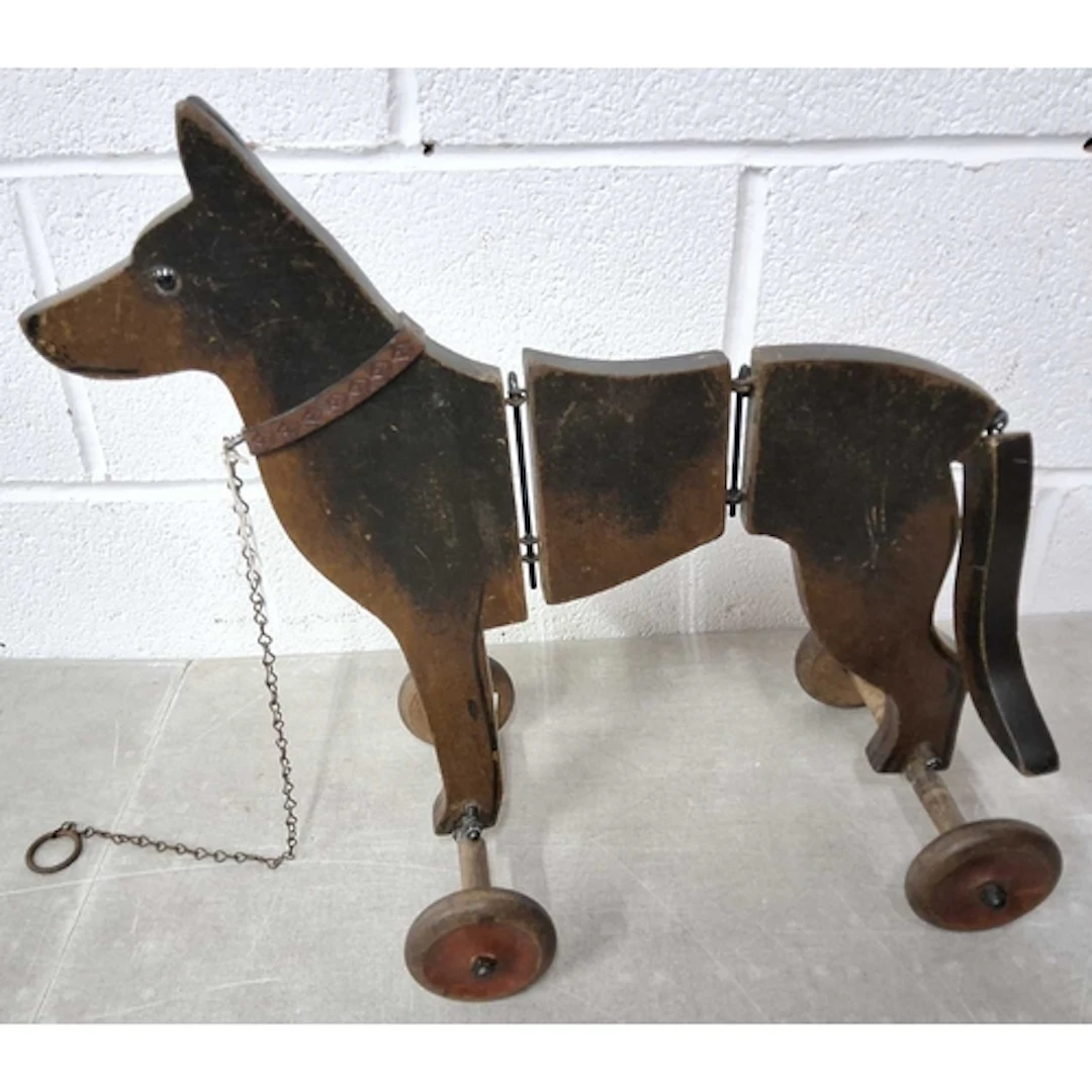 A VINTAGE ARTICULATED WOODEN PULL-ALONG DOG, with chain lead...
