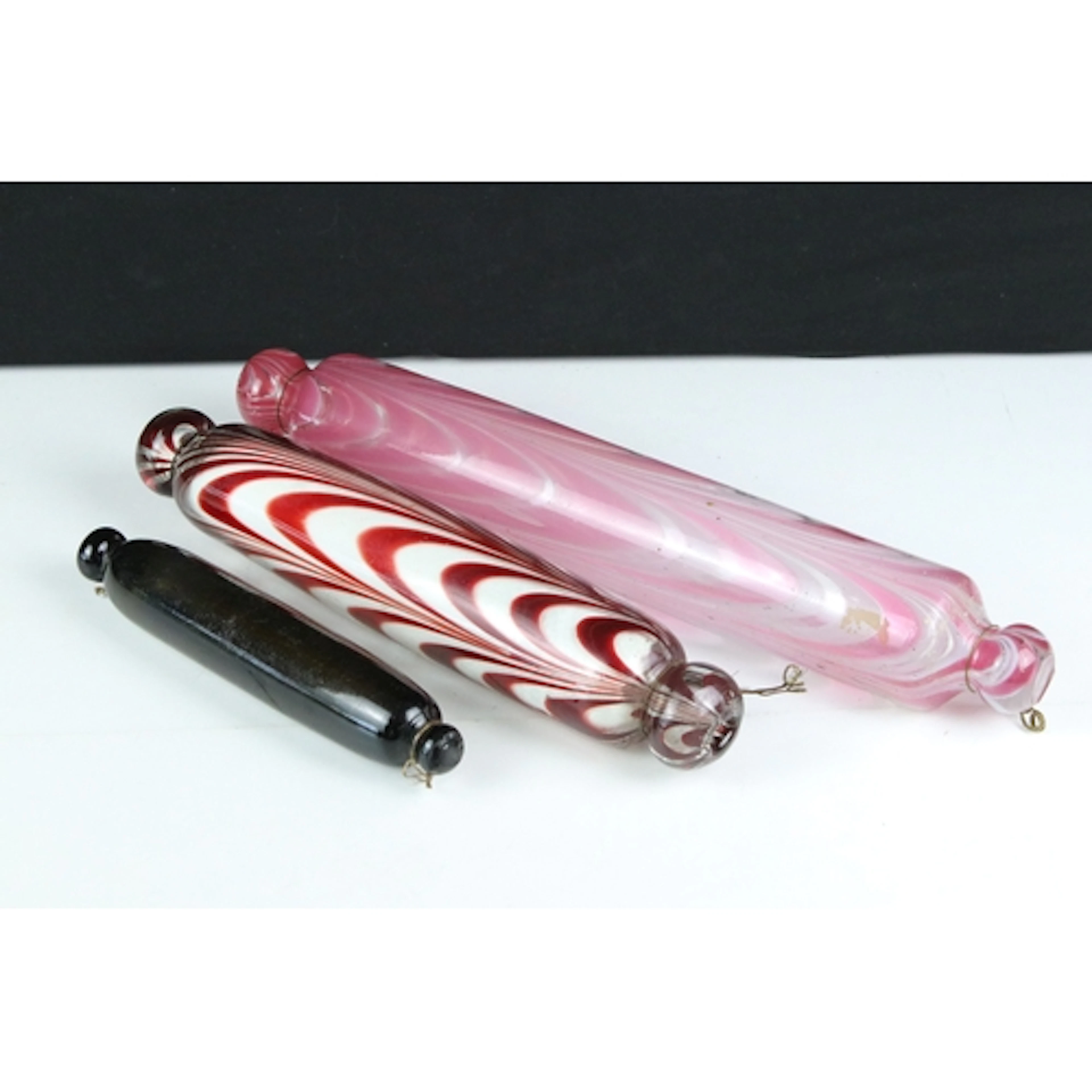 Three Victorian glass rolling pins, two having looped glass ...