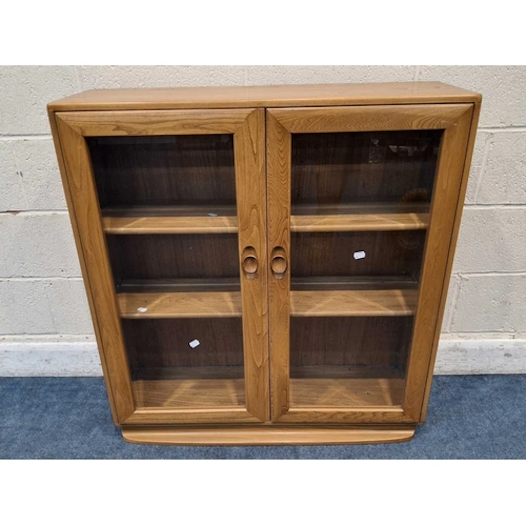 LUCIAN ERCOLANI, A MID-CENTURY ELM WINDSOR BOOKCASE, the two...