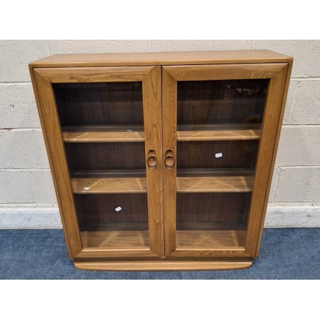 LUCIAN ERCOLANI, A MID-CENTURY ELM WINDSOR BOOKCASE, the two...