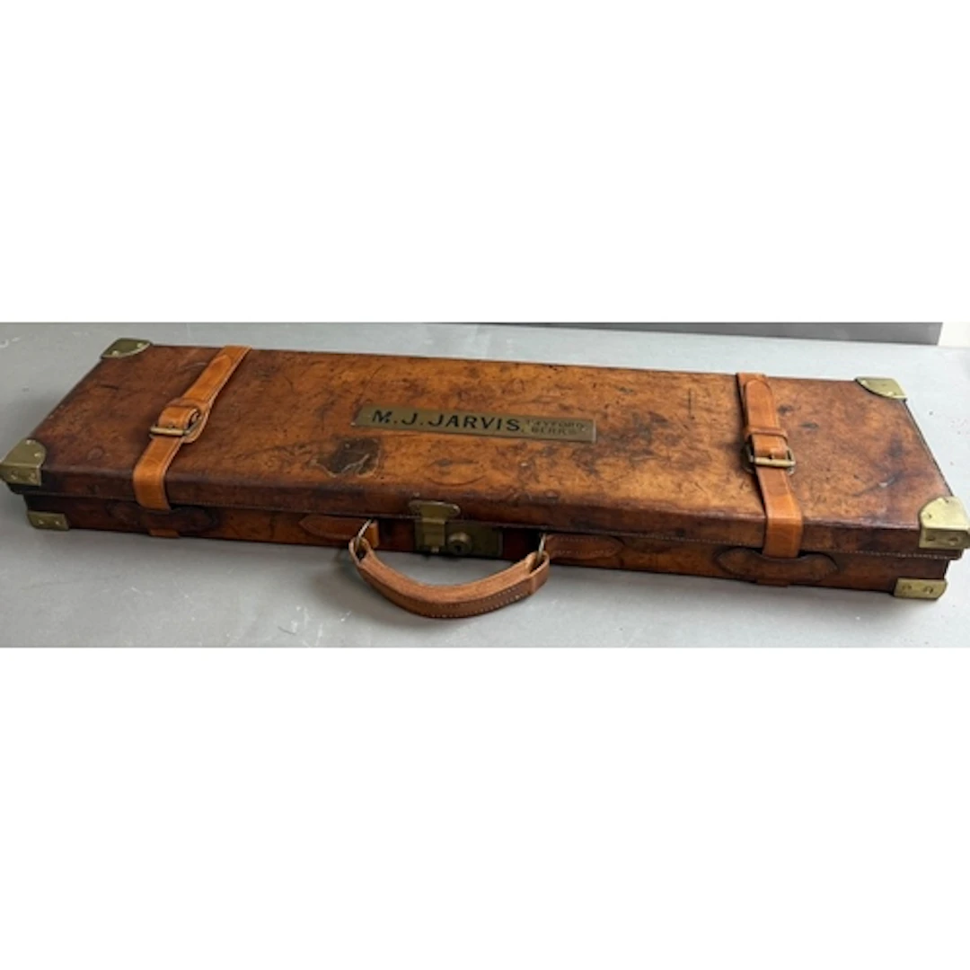A leather and brass bound gun case with brass identification...