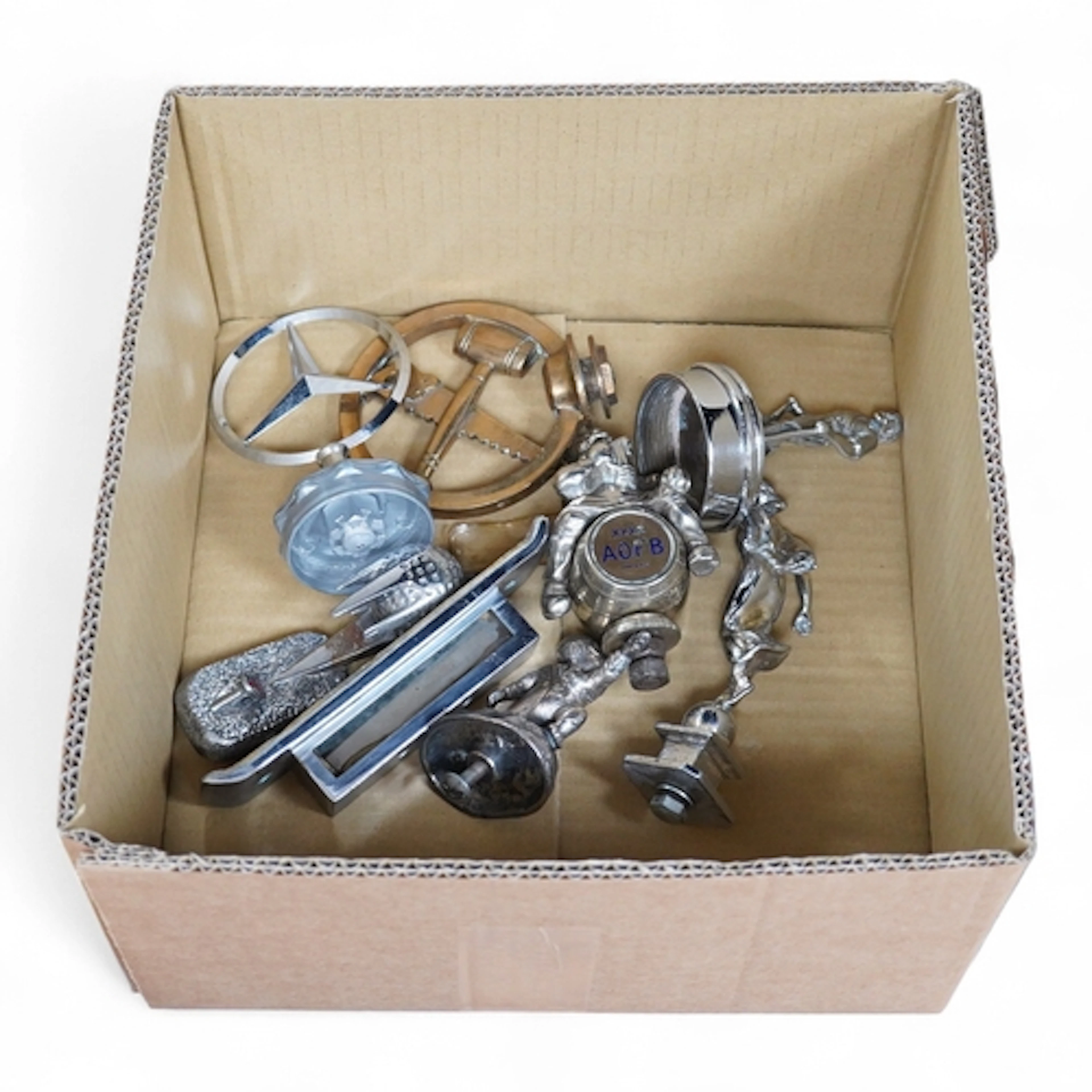 Seven chrome and brass car mascots, including a Mercedes-Ben...