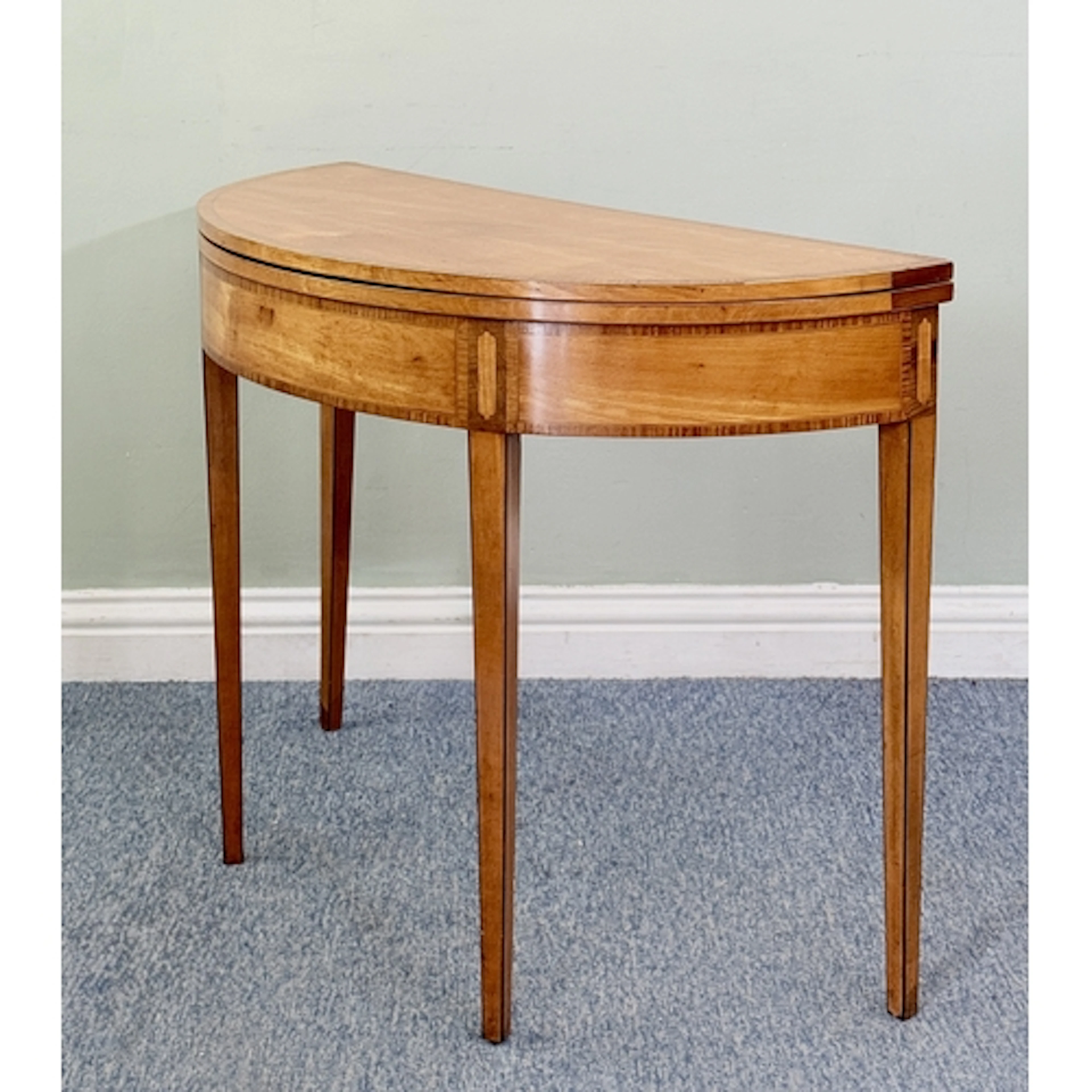 A George IV satinwood demi-lune card table - the foldover to...