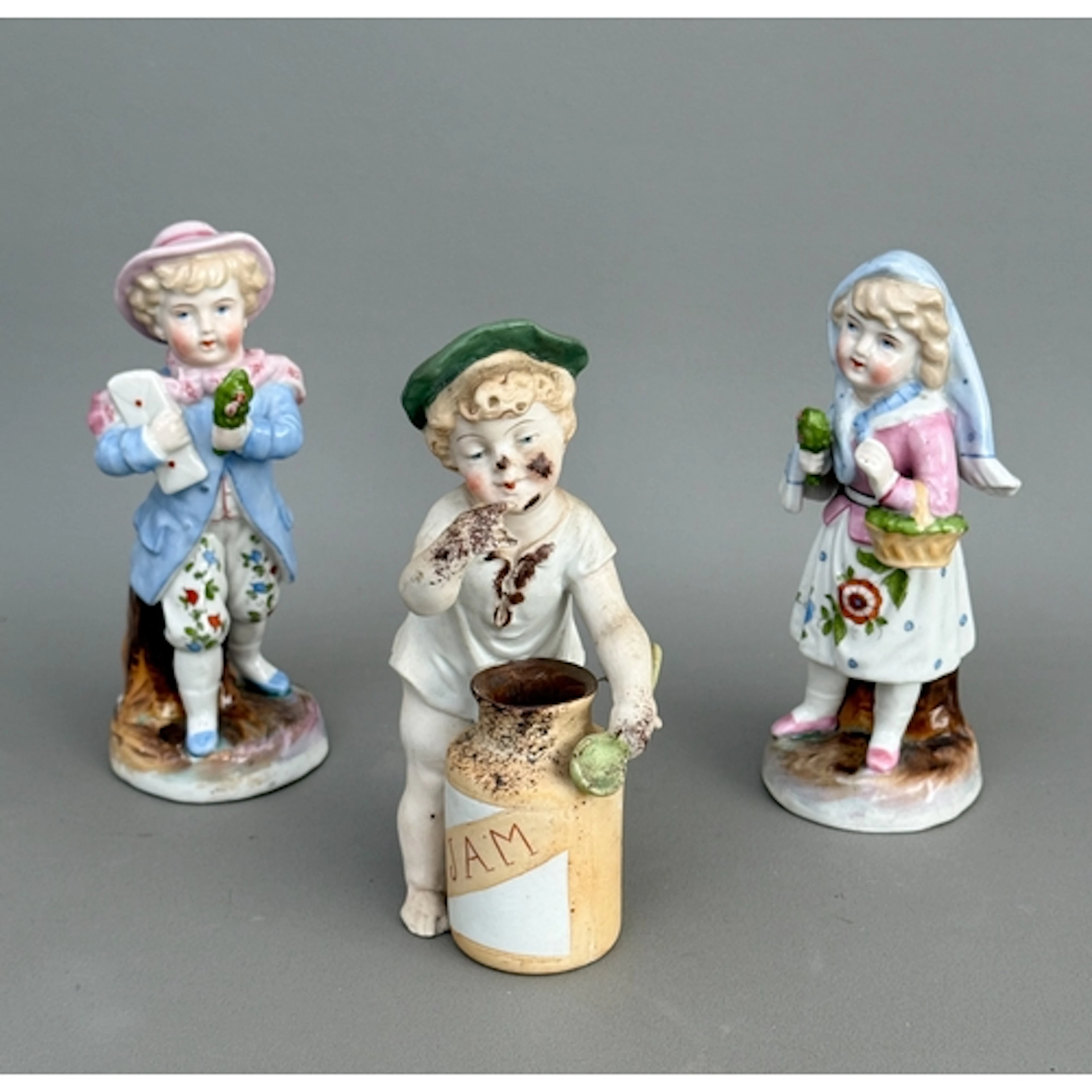 A pair of continental porcelain figurines of a girl and boy ...