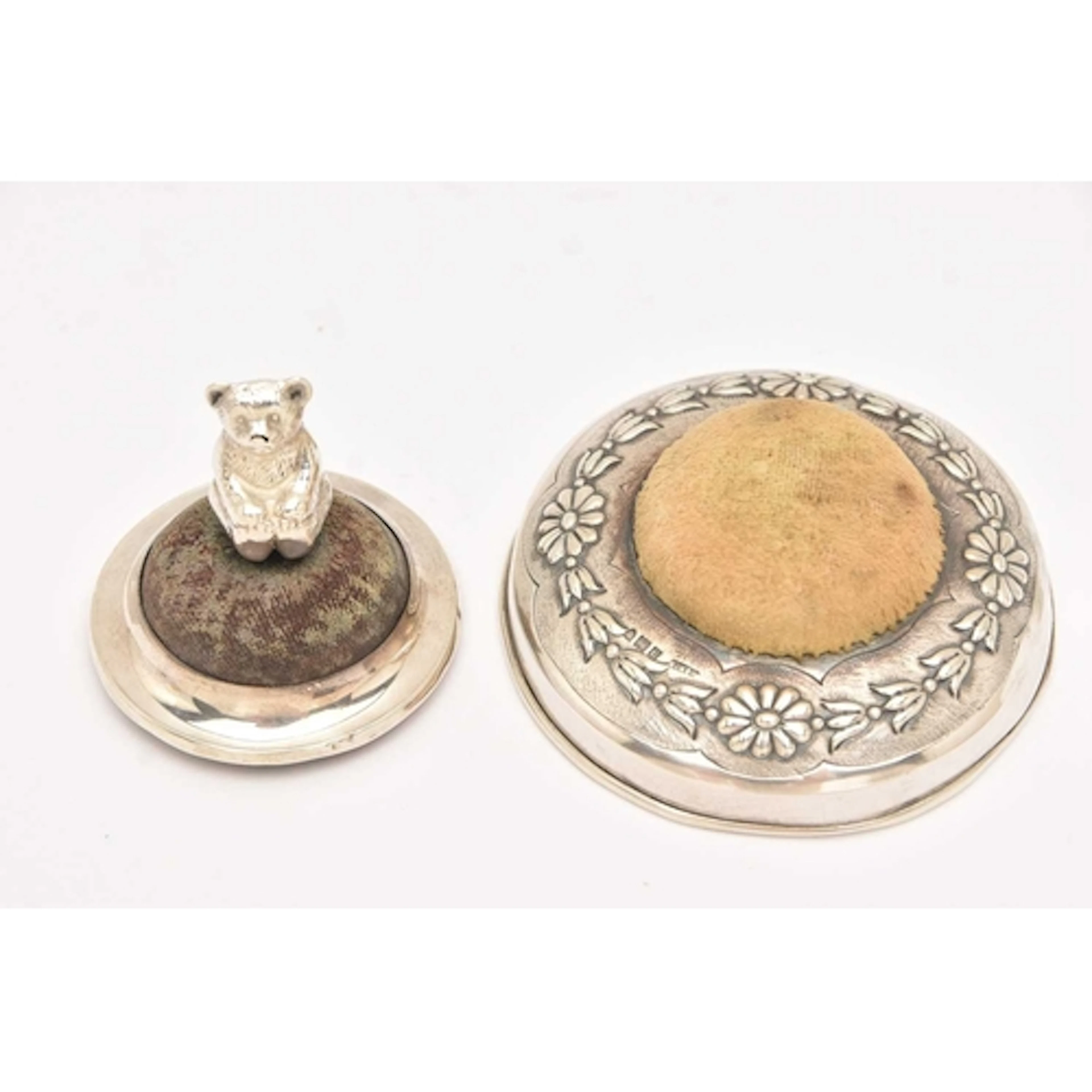 TWO SILVER PIN CUSHIONS, the first an small circular form pi...