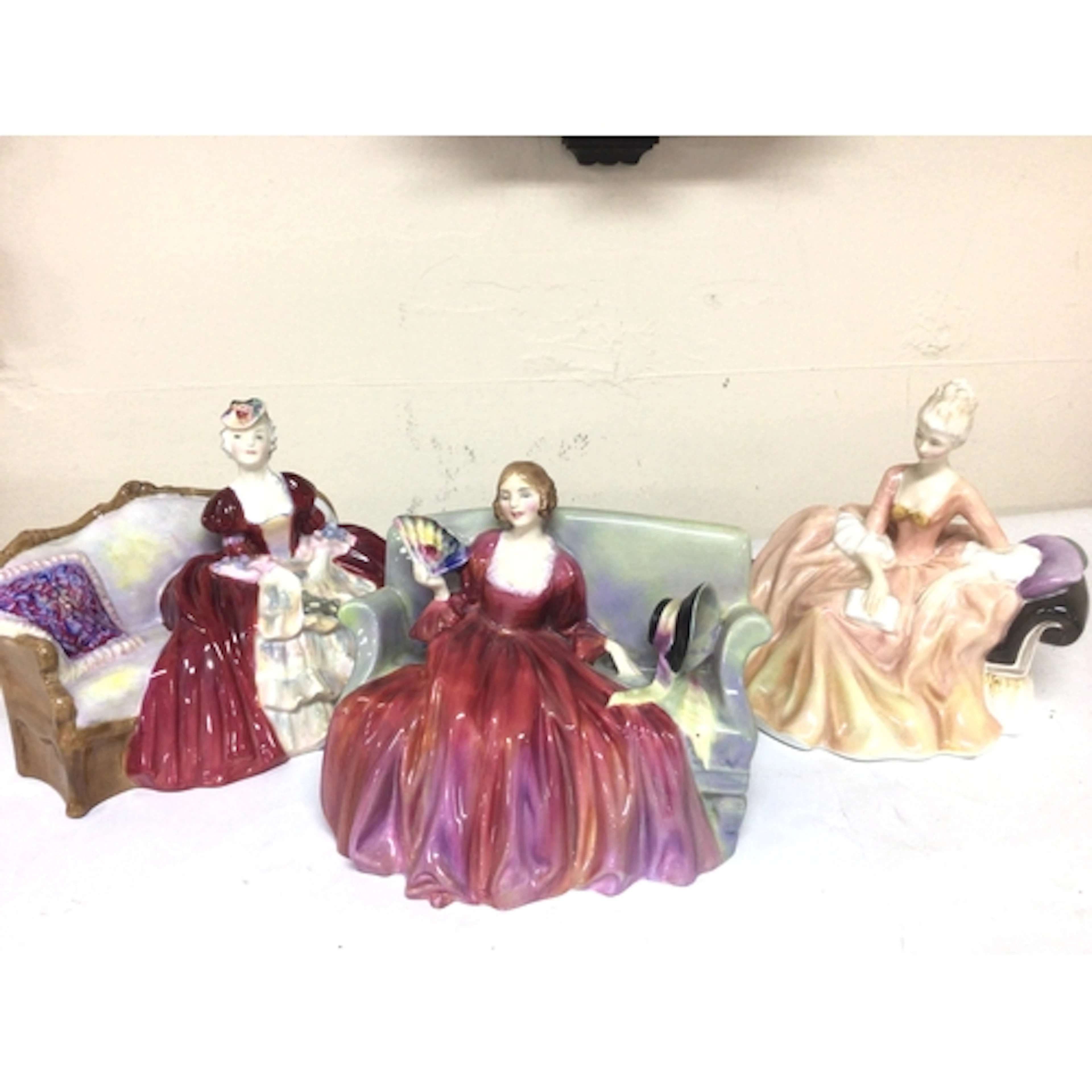 Three Royal Doulton lady figures seated on sofas sweet...