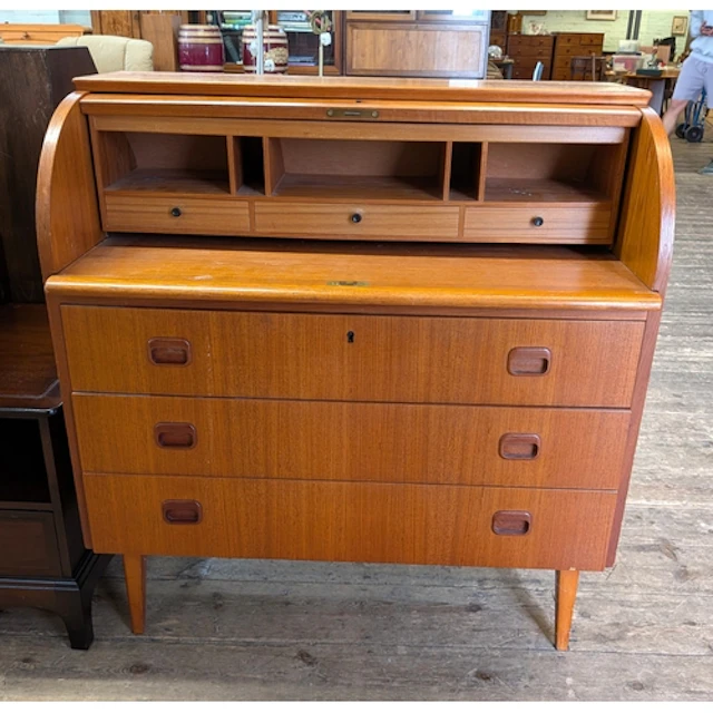 A modern teak cylinder top bureau with three long drawers un...
