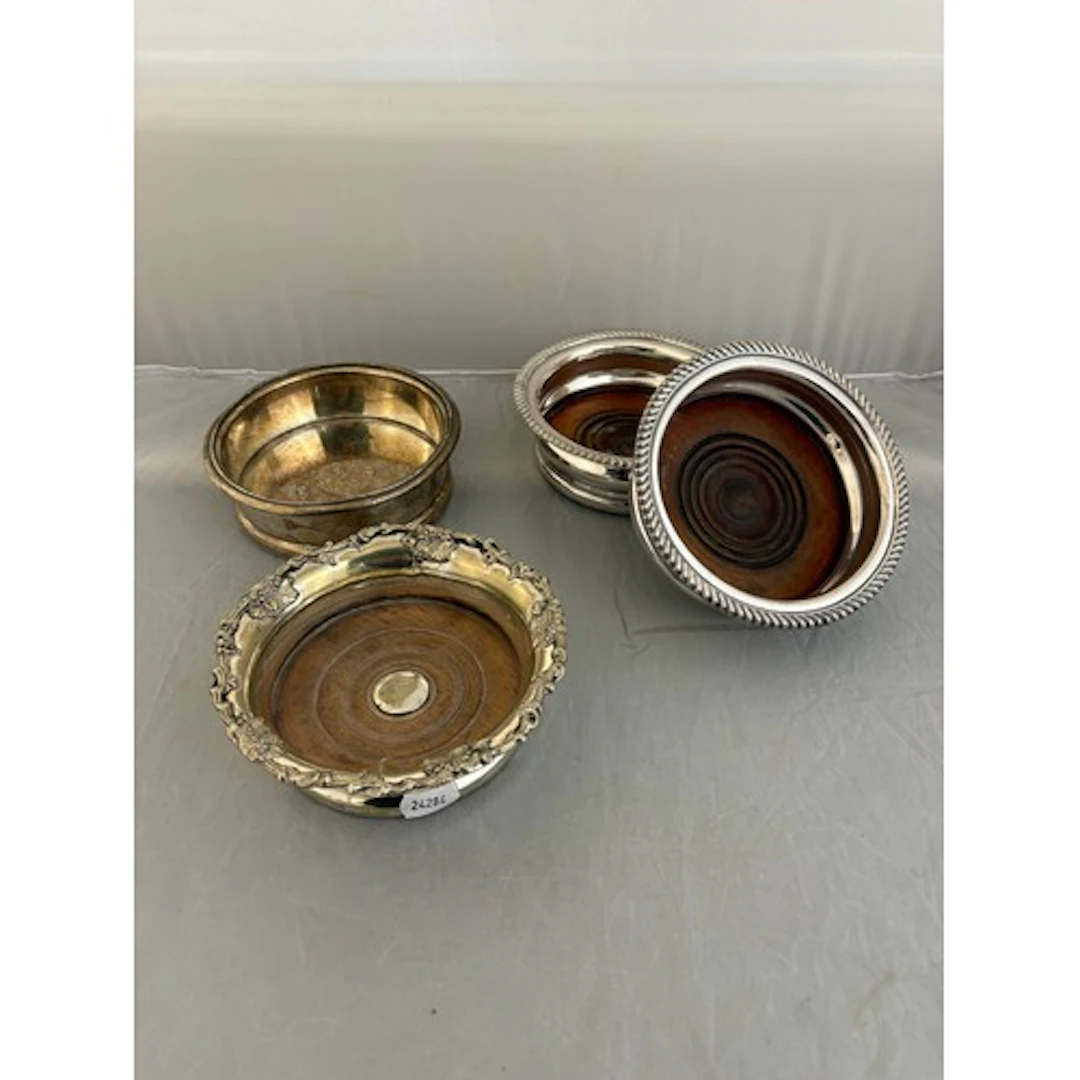 A pair of silver plated bottle coaster and two further coast...