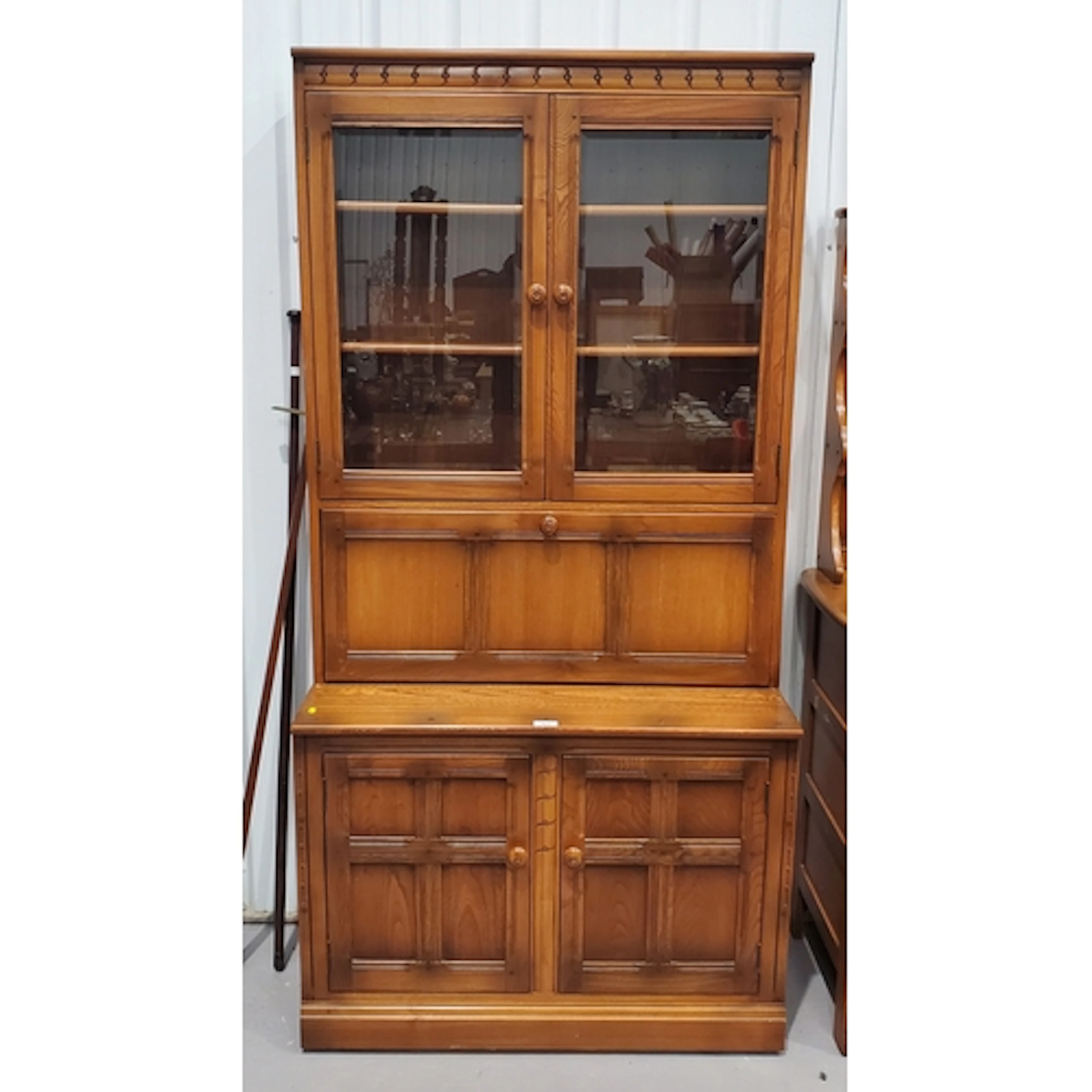 An Ercol Bookcase fitted pair of glazed doors above single d...