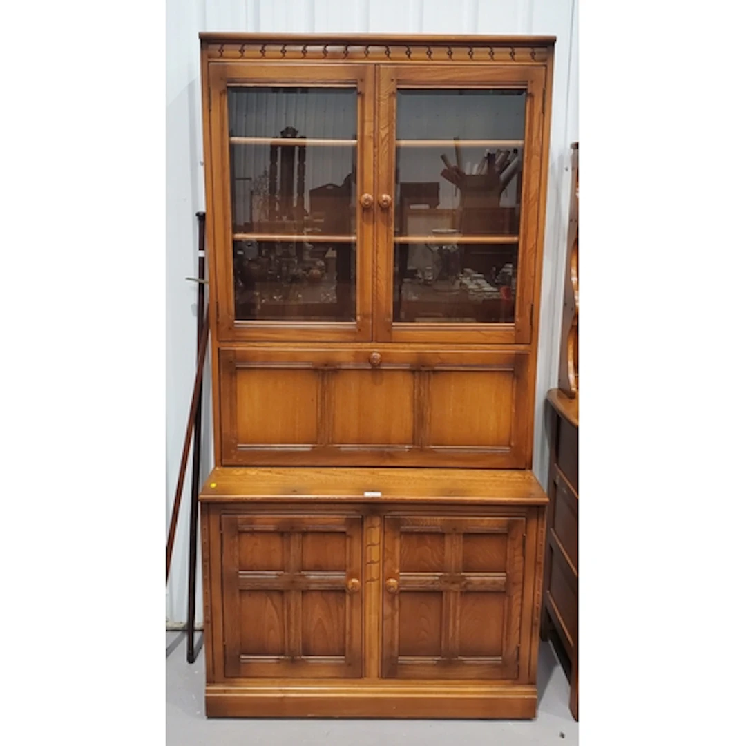 An Ercol Bookcase fitted pair of glazed doors above single d...