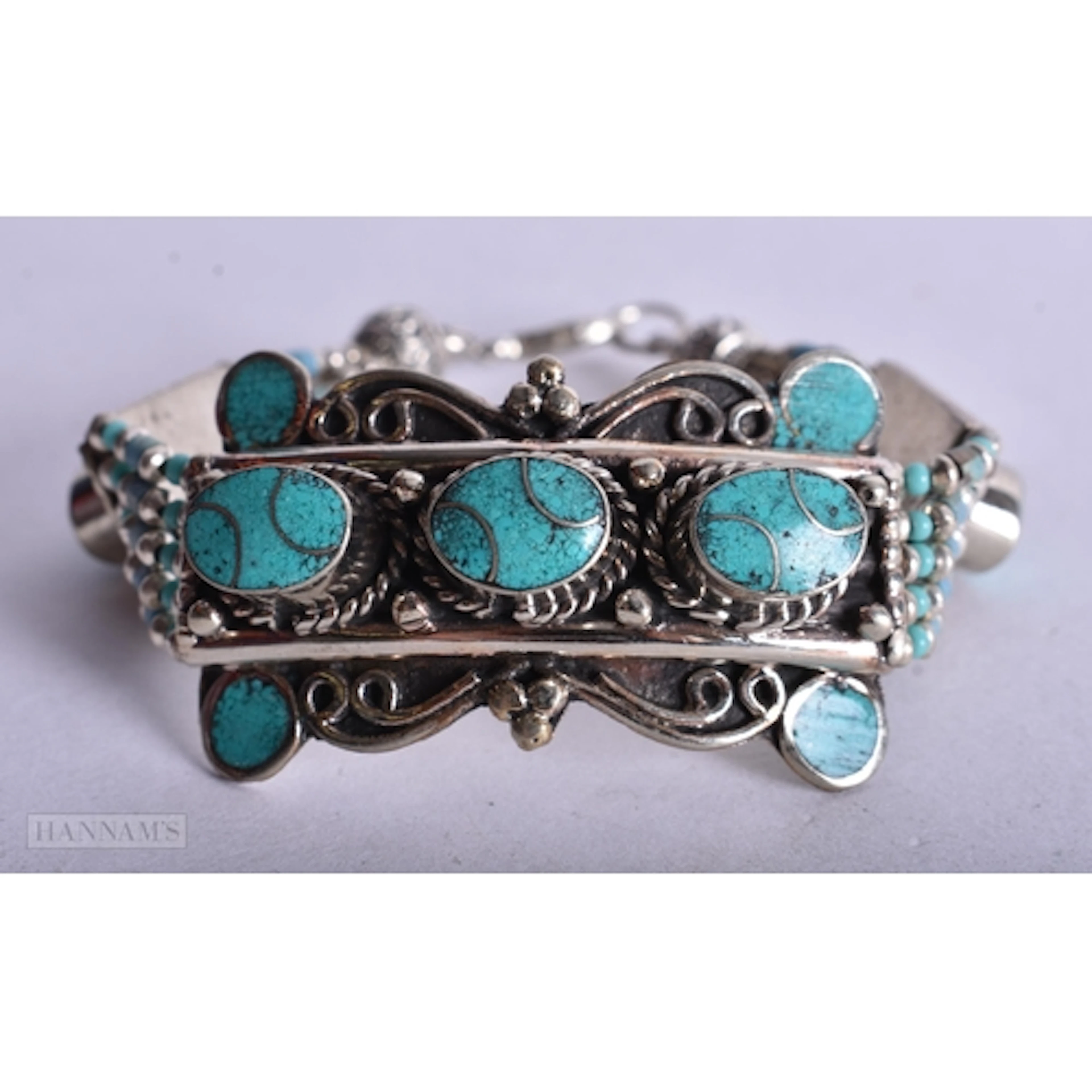 A TIBETAN WHITE METAL AND TURQUOISE BRACELET. 17 x 2.8 cm. 4...