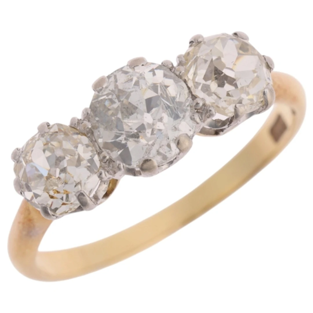 An 18ct gold three stone diamond ring, claw set with old-cut...