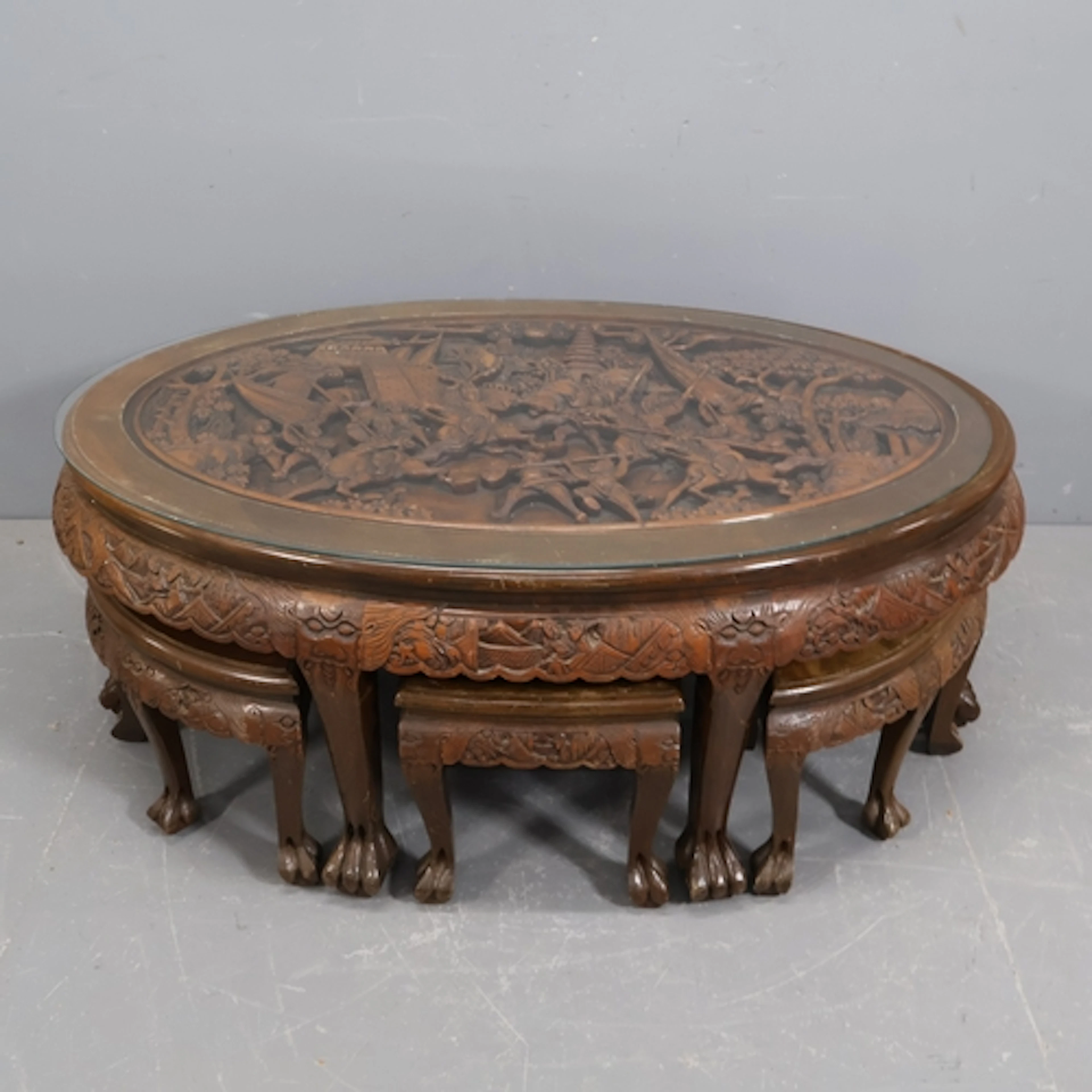 A large Chinese oval coffee table, profusely relief carved w...
