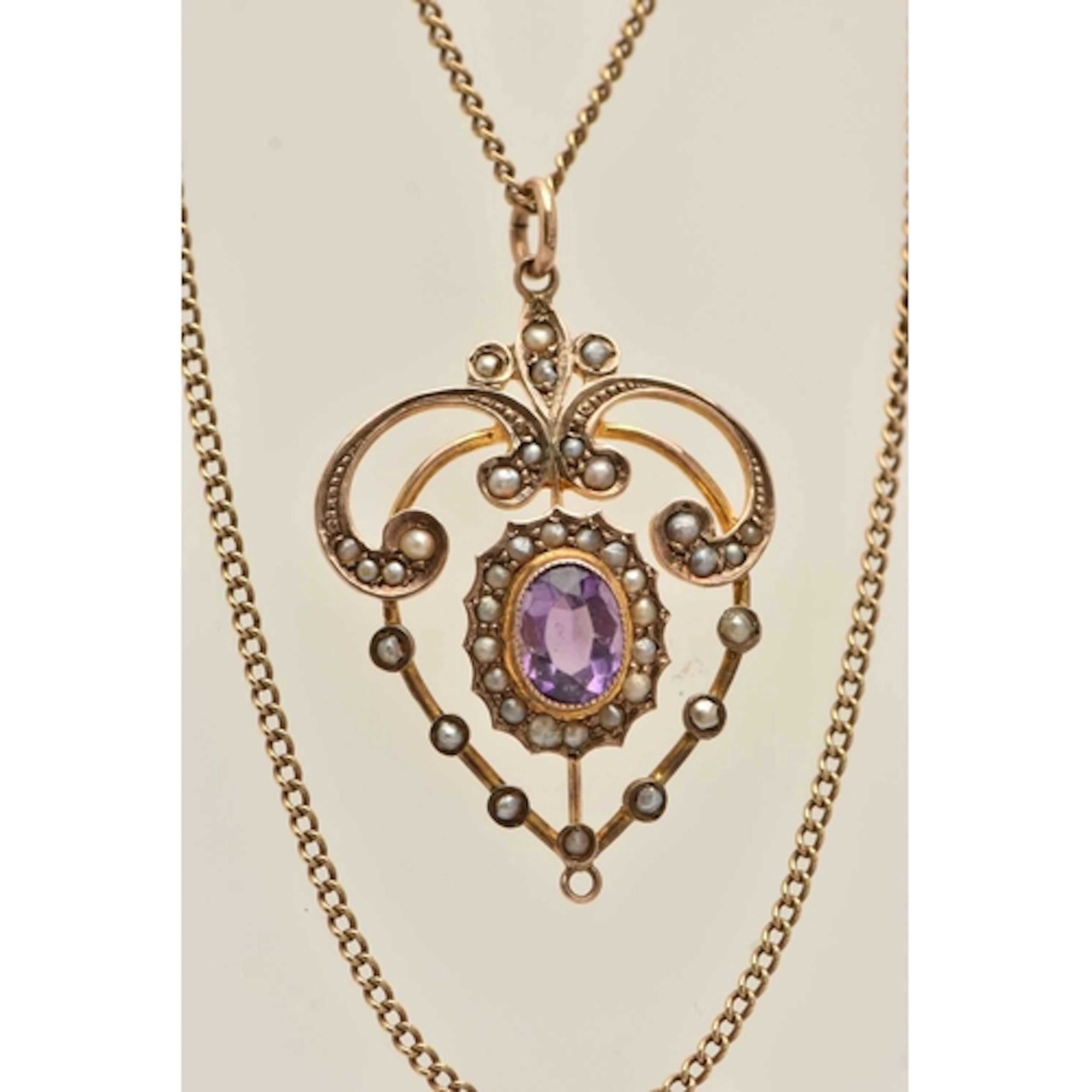 A YELLOW METAL LAVALIER PENDANT NECKLACE, the pendant set wi...