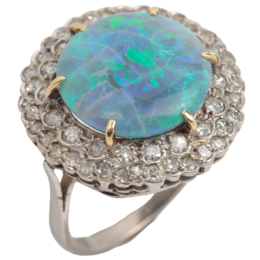 An opal and diamond cluster ring, claw-set with a circular b...