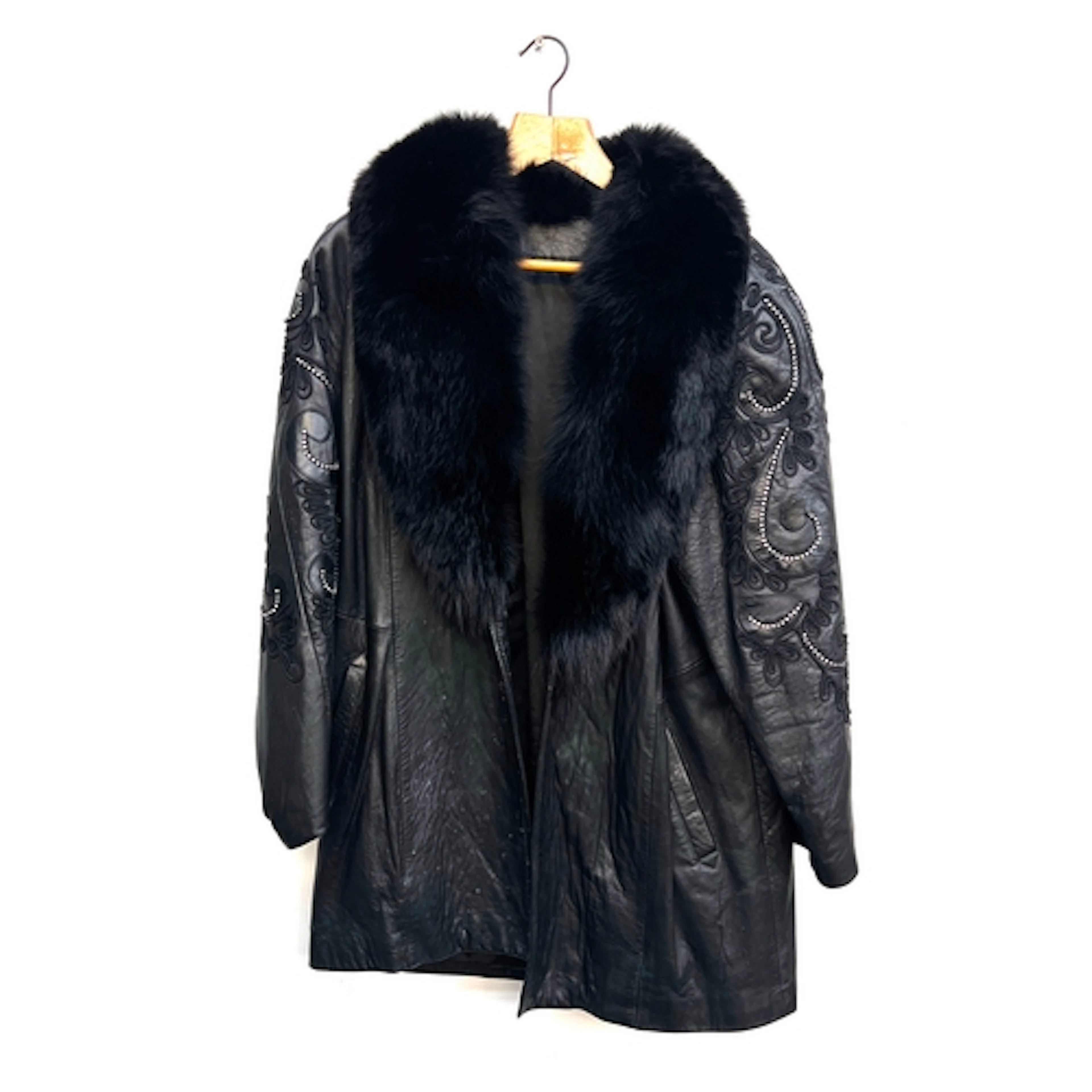 A black leather coat with fur collar and rhinestone detail t...