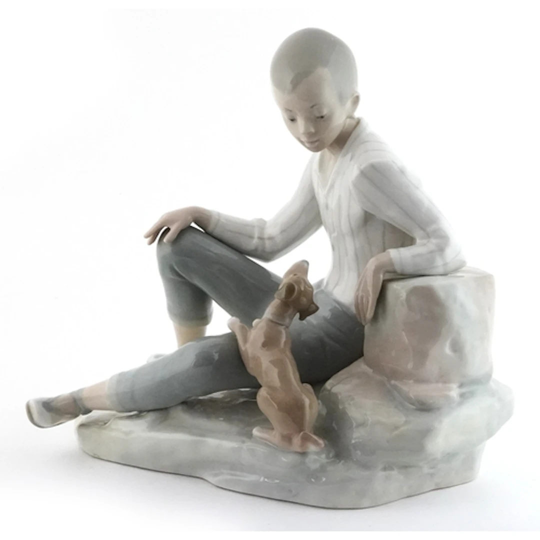 Lladro porcelain figure group of a boy with dog, 25cm high.