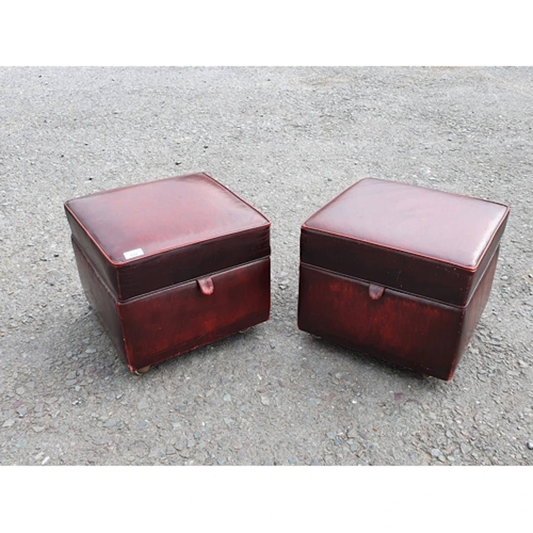 A pair of leather upholstered Footstools bearing the label '...
