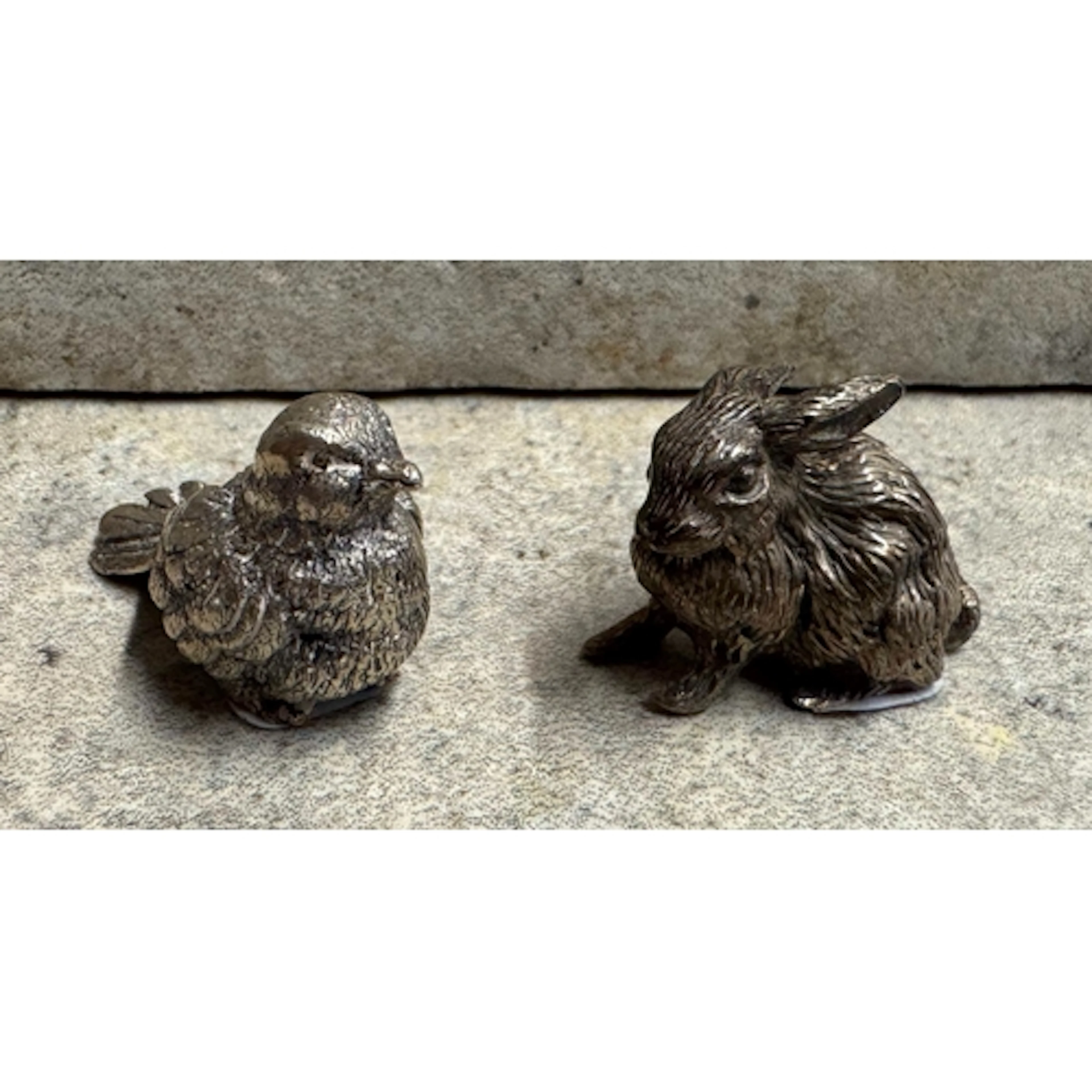 A heavy cast silver figure of a rabbit with textured body, t...
