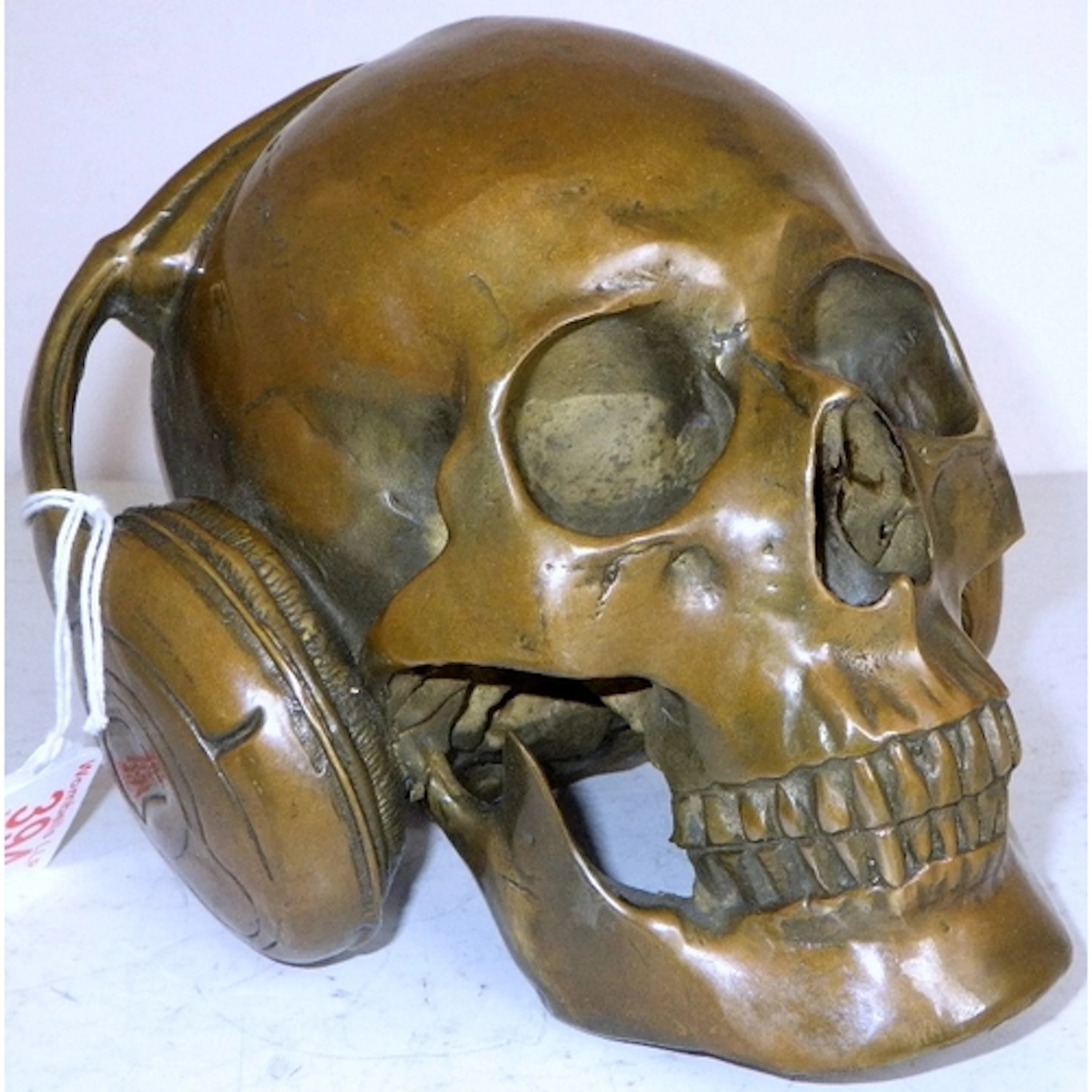A large bronze skull wearing headphones