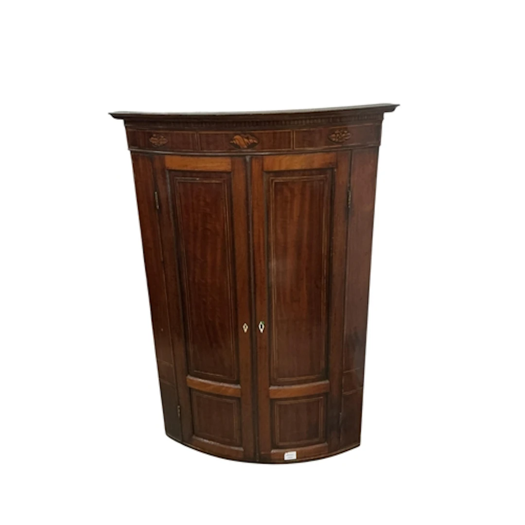 A George III mahogany bowfronted hanging corner cupboard, wi...