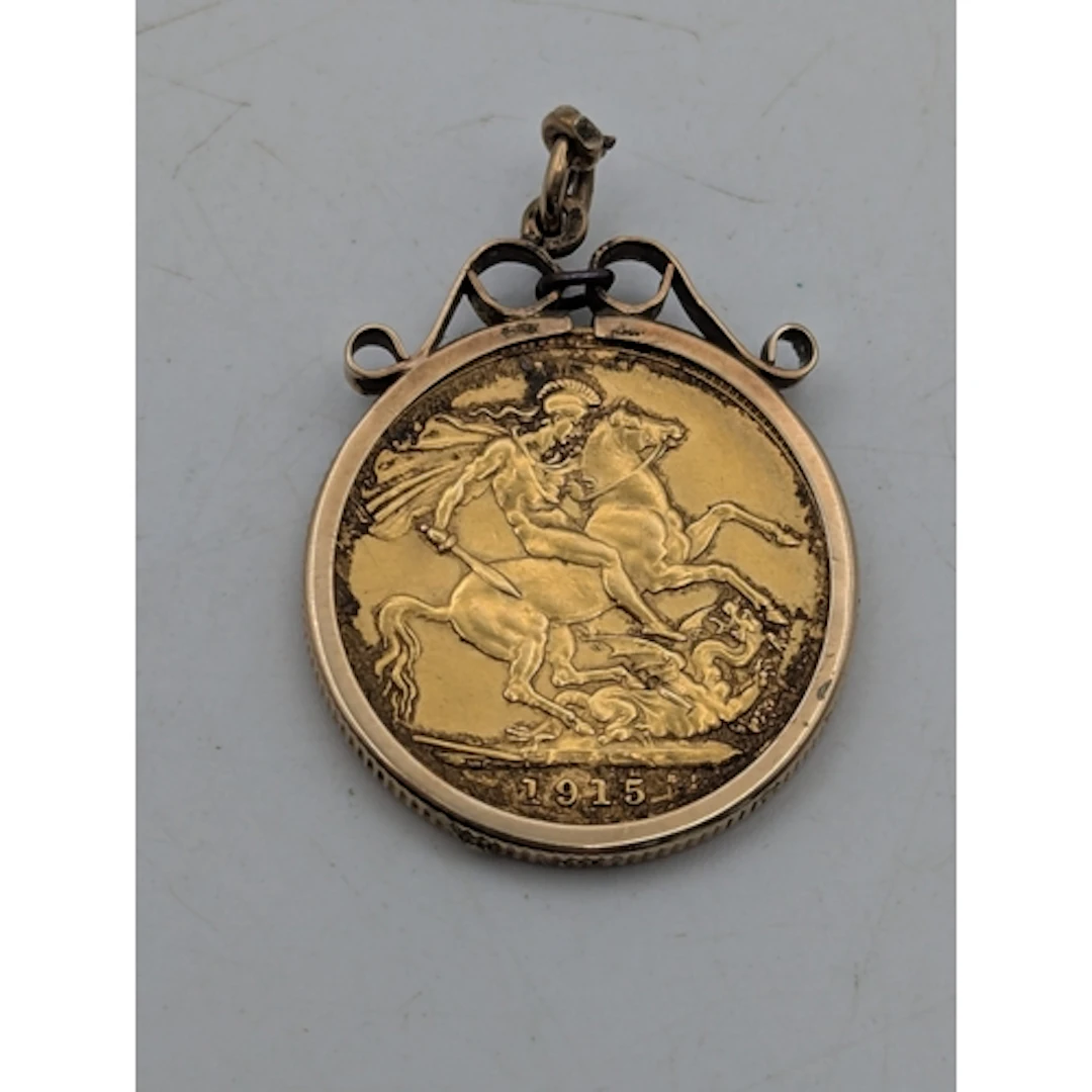 A 1915 sovereign, mounted in a 9ct yellow gold frame A/F, wi...