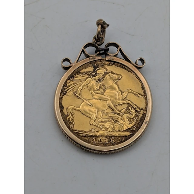 A 1915 sovereign, mounted in a 9ct yellow gold frame A/F, wi...