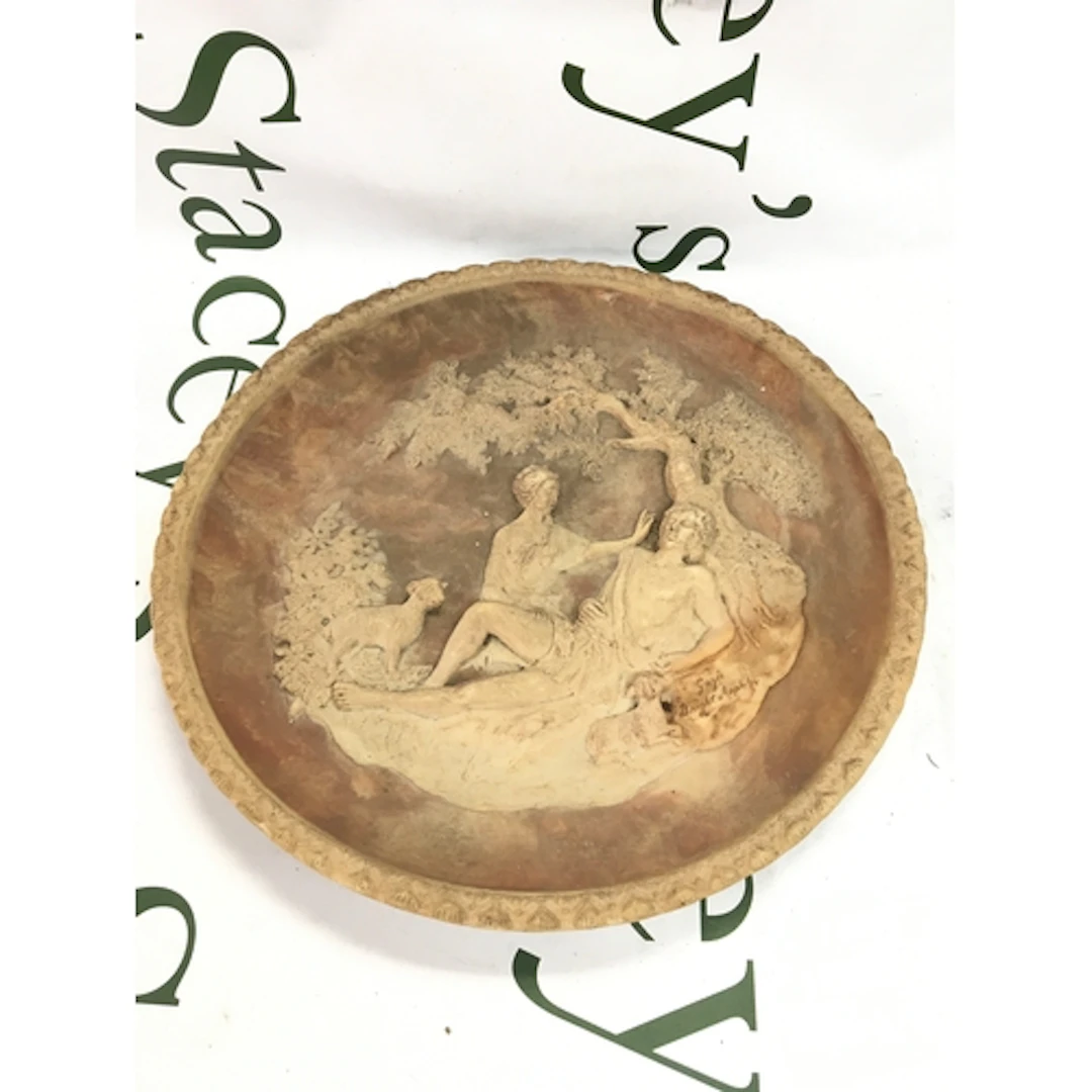 A 19th century pottery dish with raised figures under a tree...