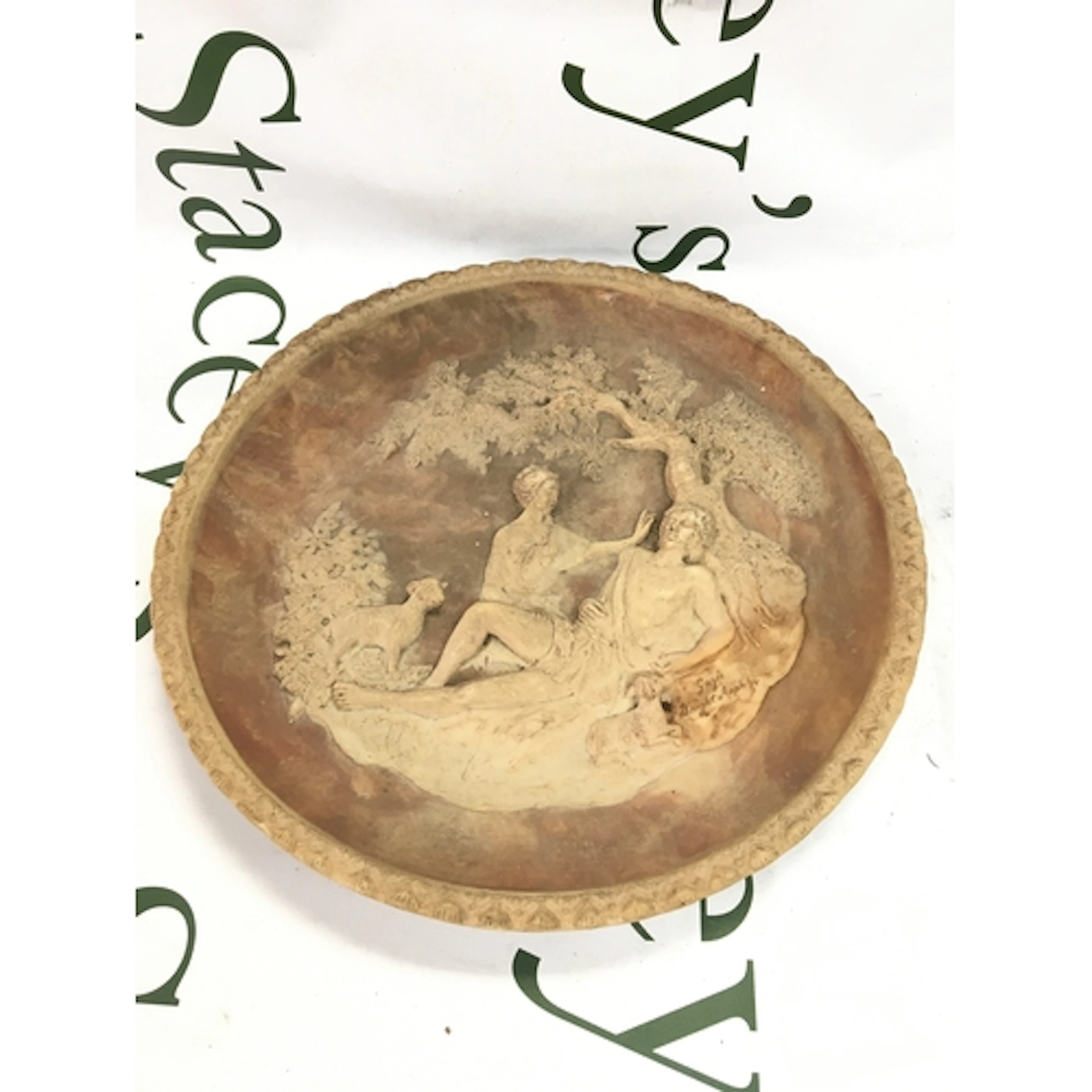 A 19th century pottery dish with raised figures under a tree...