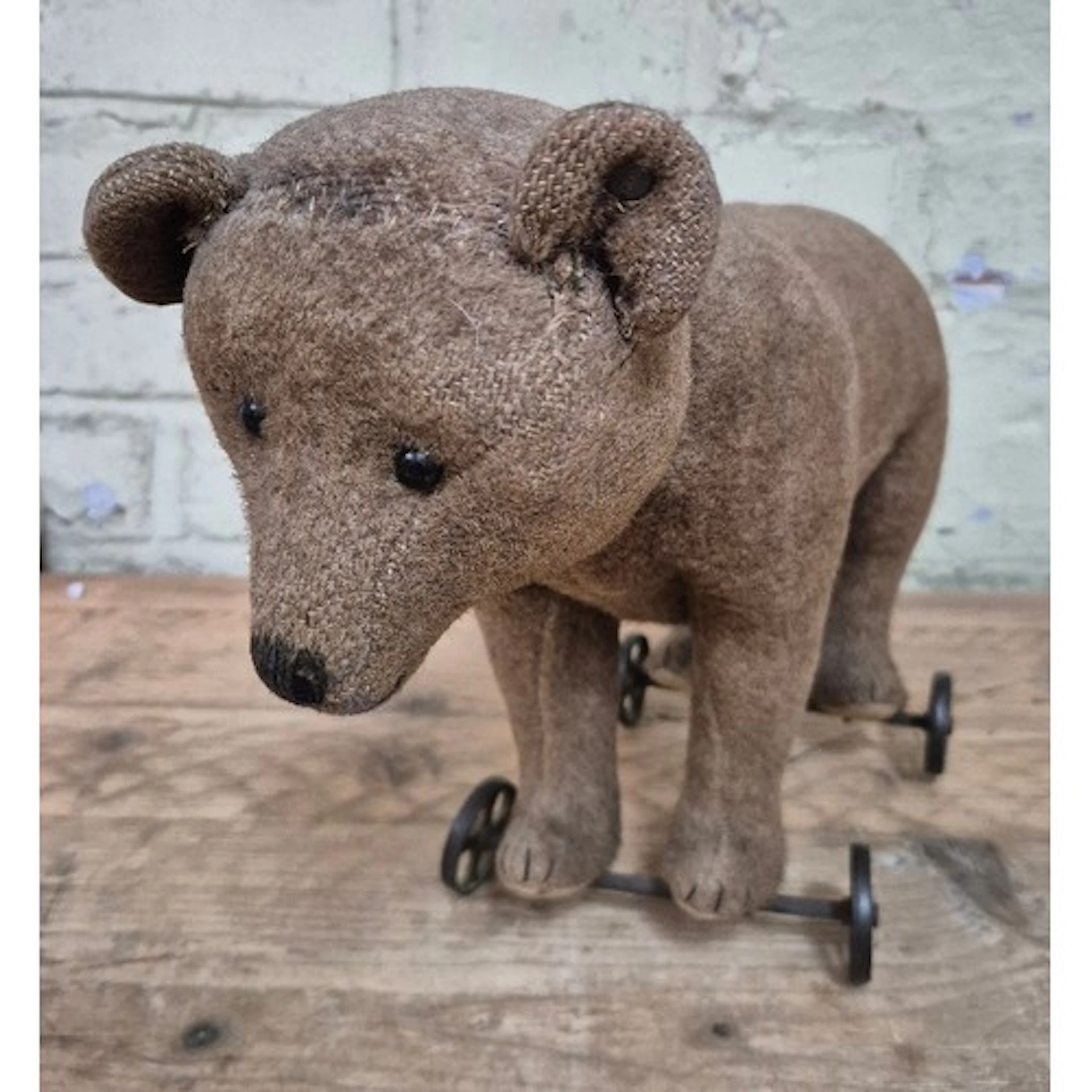 A vintage Steiff bear on wheels, 38cm in length.