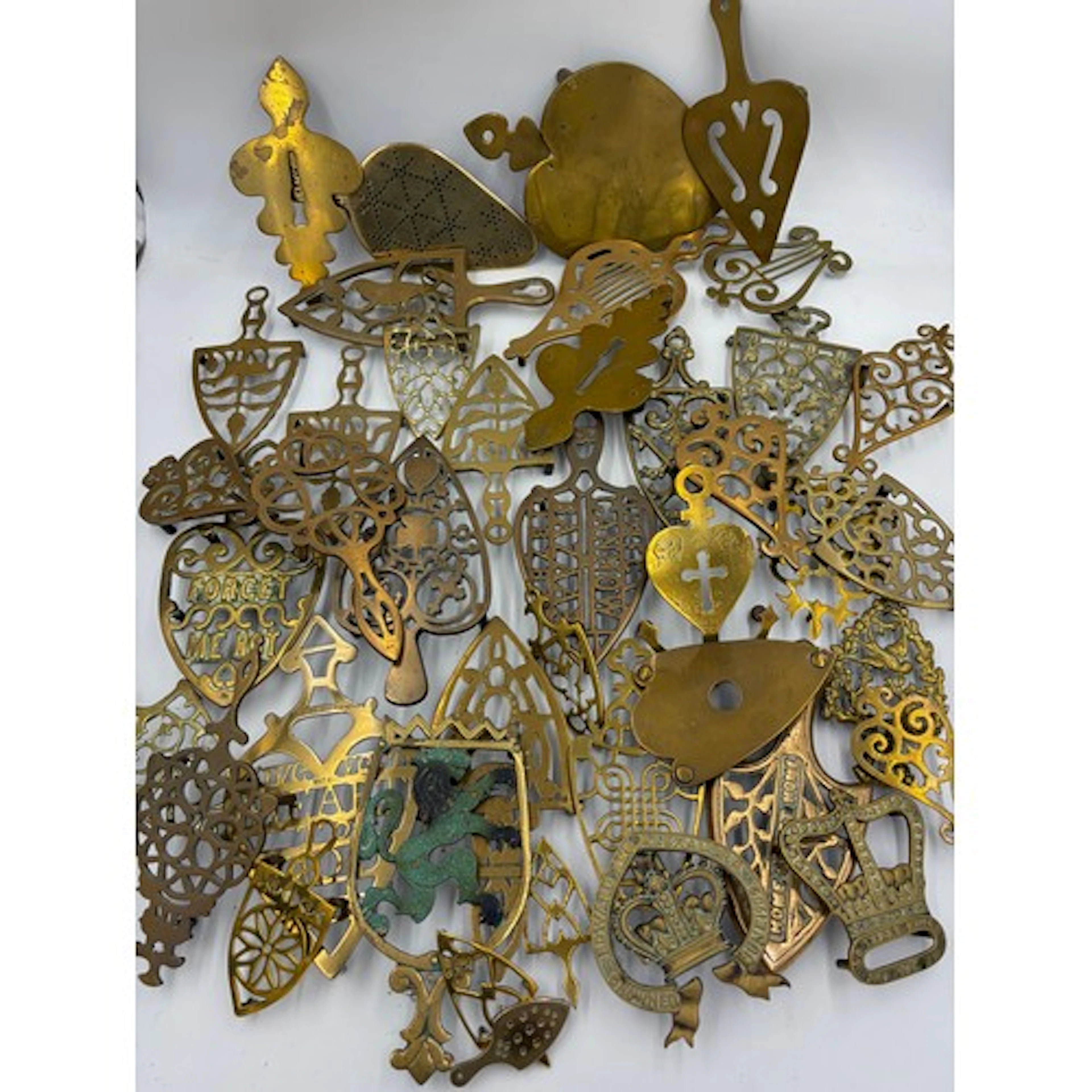 A large collection of brass trivets to include 'Forget me no...