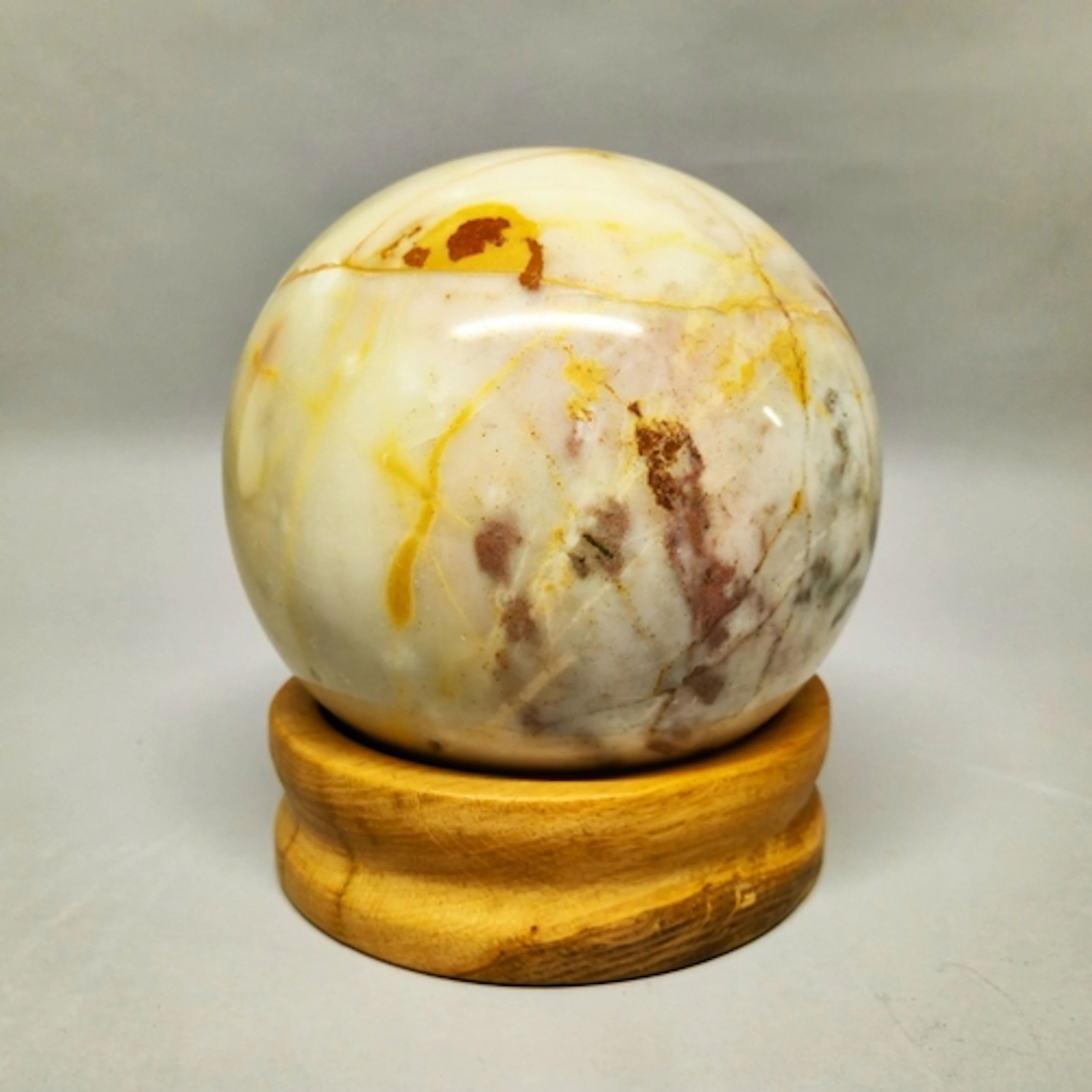 Onyx sphere of large proportions, on burr wood stand, approx...