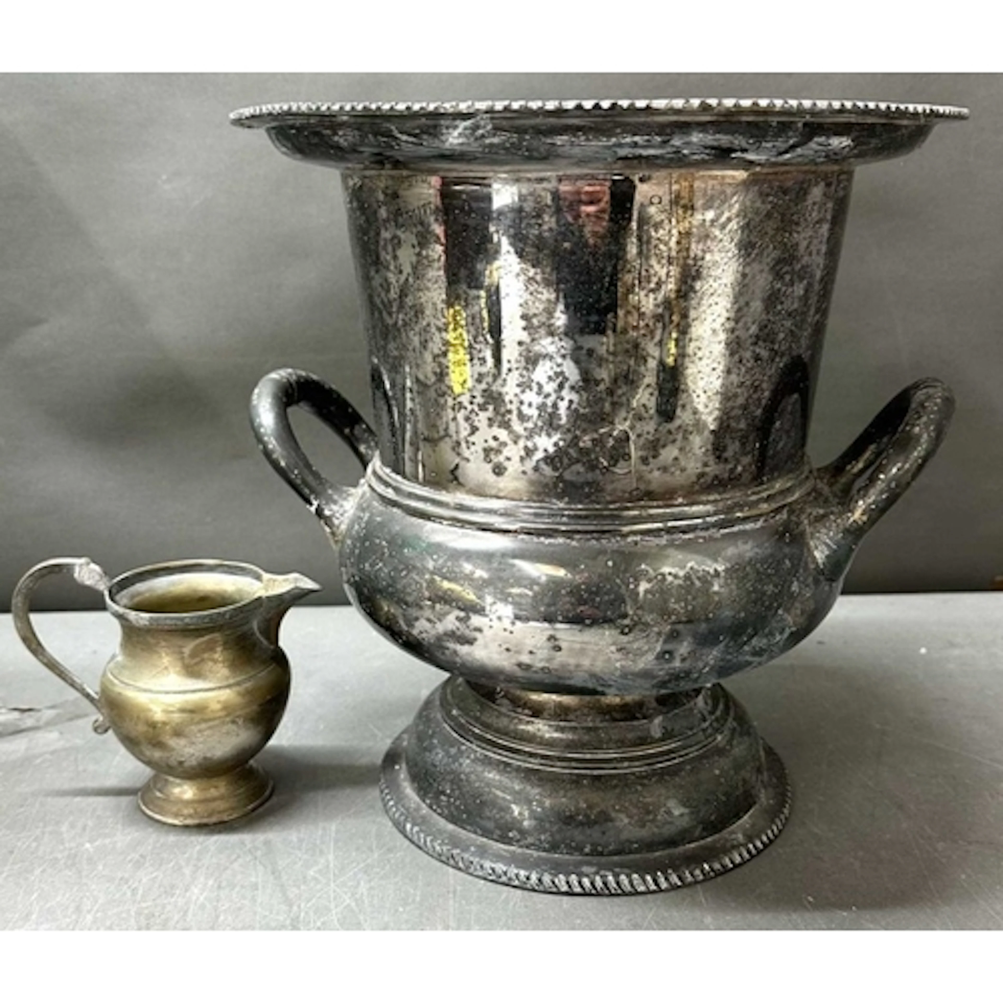 A vintage EPNS champagne bucket with a pedestal base and twi...