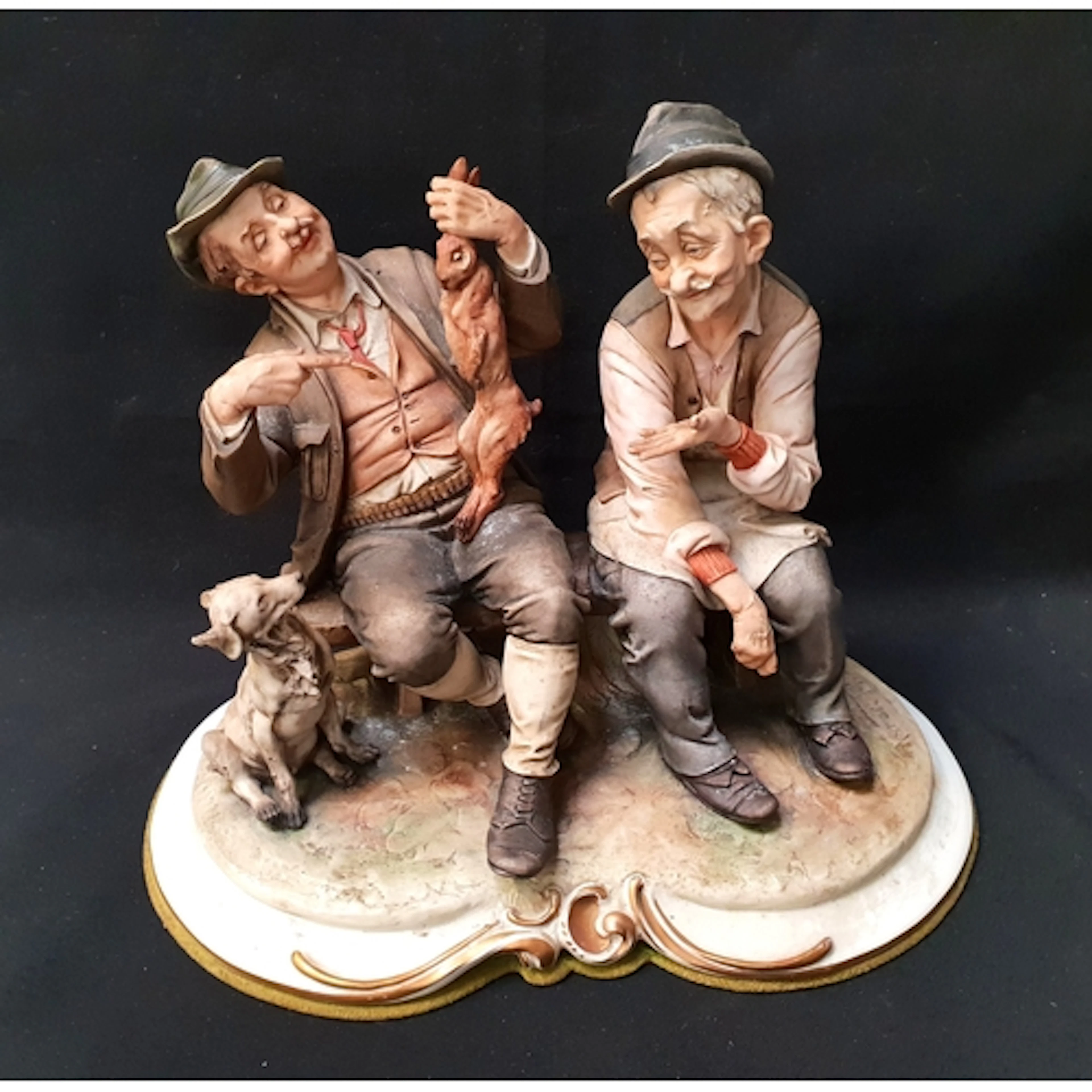 CAPODIMONTE FIGURAL SCENE depicting two men seated on a ben...