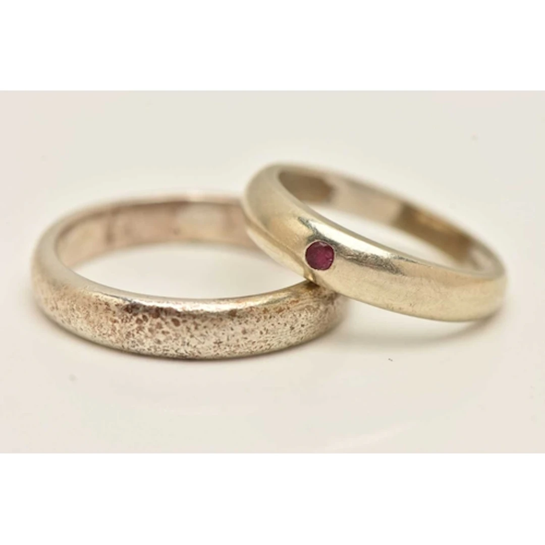 A 9CT WHITE GOLD RUBY SET RING AND A WHITE METAL BAND RING, ...